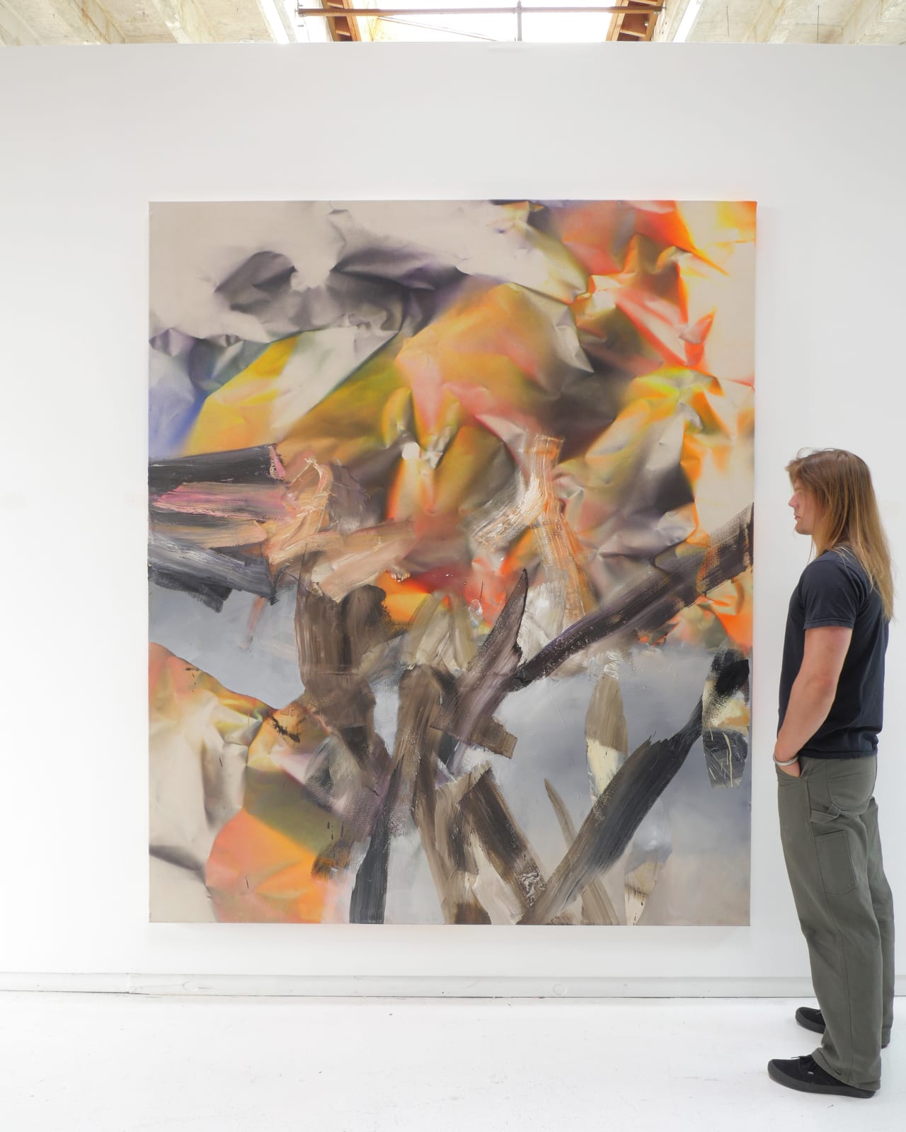 Install view of painting with white man (right) admiring painting
