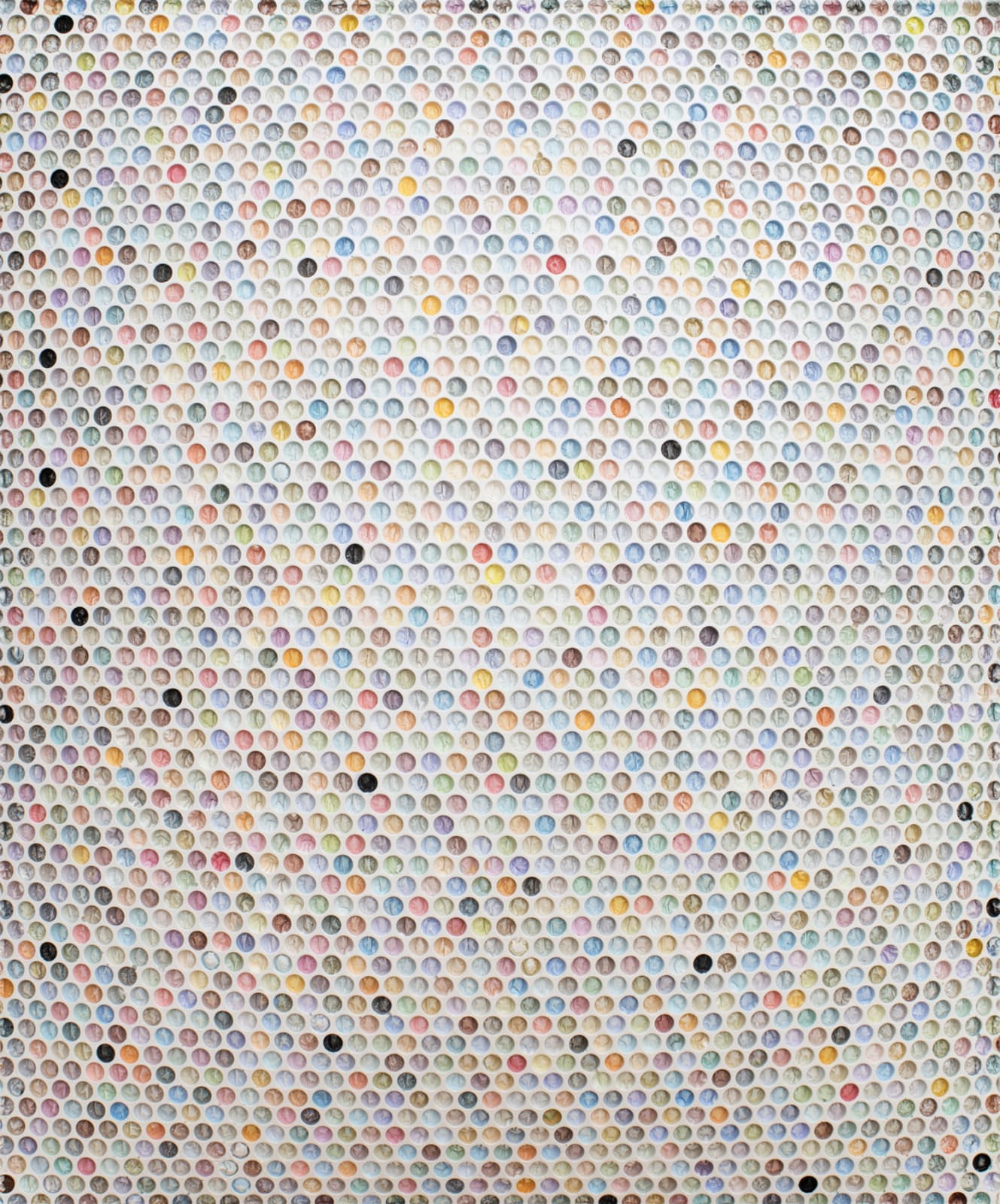 bubble wrap indents cast into plaster and painted in various pastel colors with a few ones done randomly in black