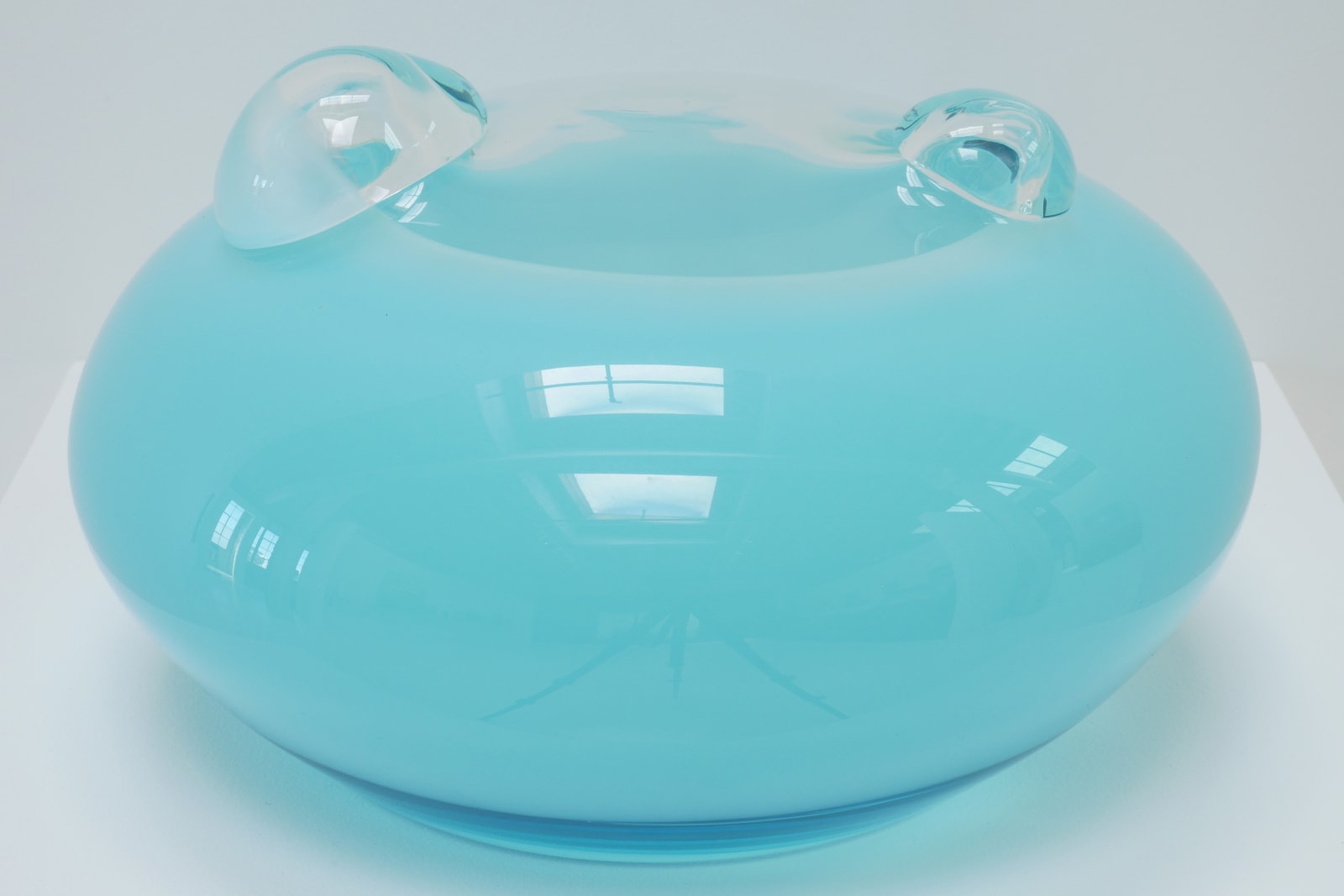 A light blue UFO-shaped sculpture with two clear bubbles on top.