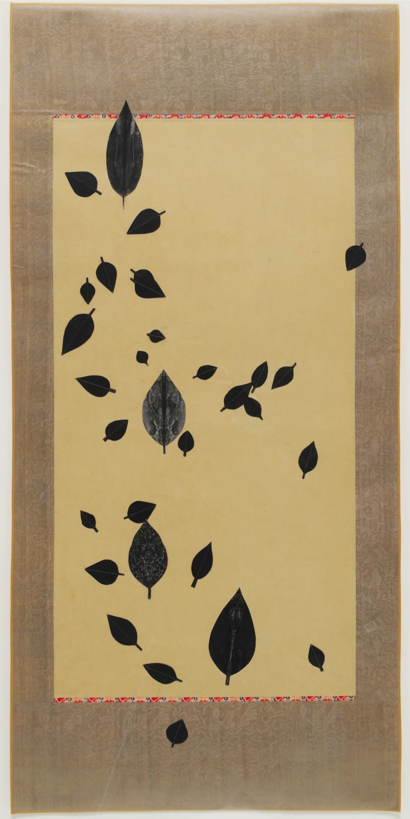 Black leaves dispersed on a beige scroll.