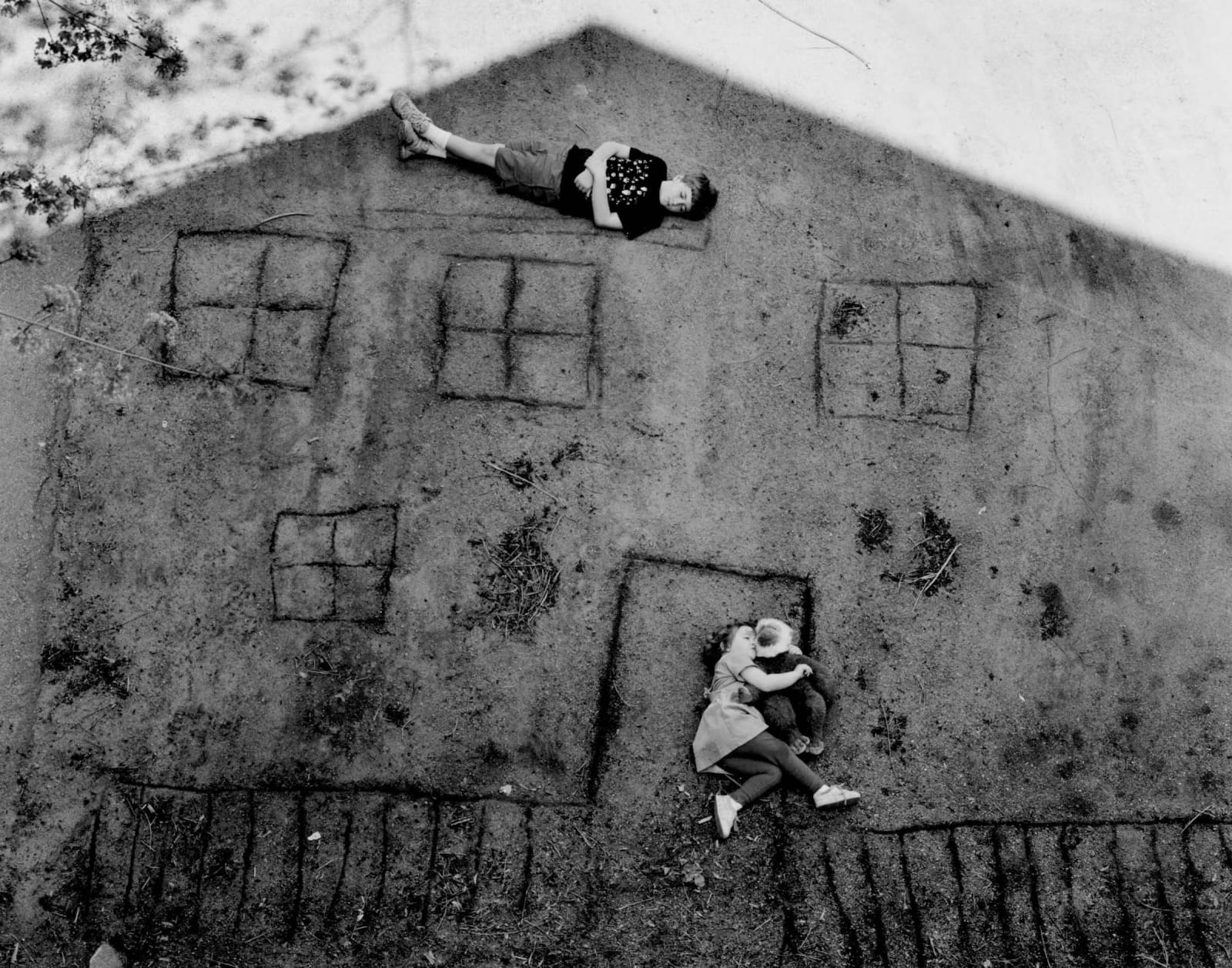 Abelardo Morell Laura and Brady in the Shadow of Our House black and white kids lying on ground