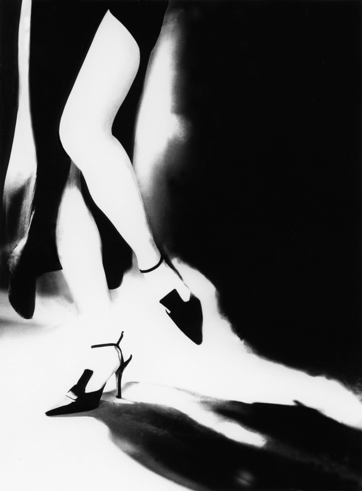 Lillian Bassman photograph of woman's legs in black heels, with slit in dress