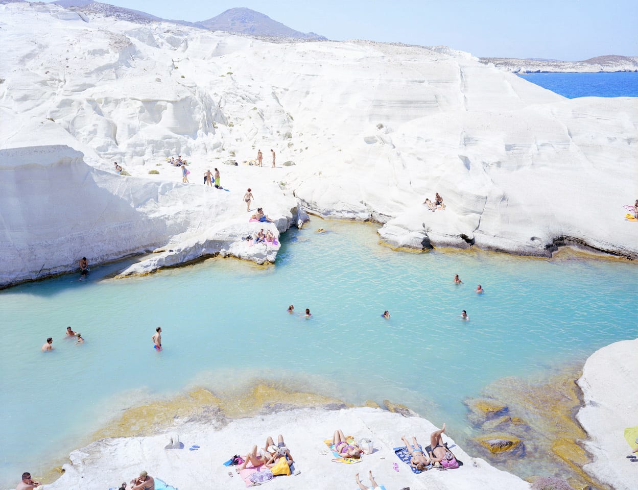 Sarakiniko Beach on Milos Island, Greece with swimmers and sunbathers, by Massimo Vitali