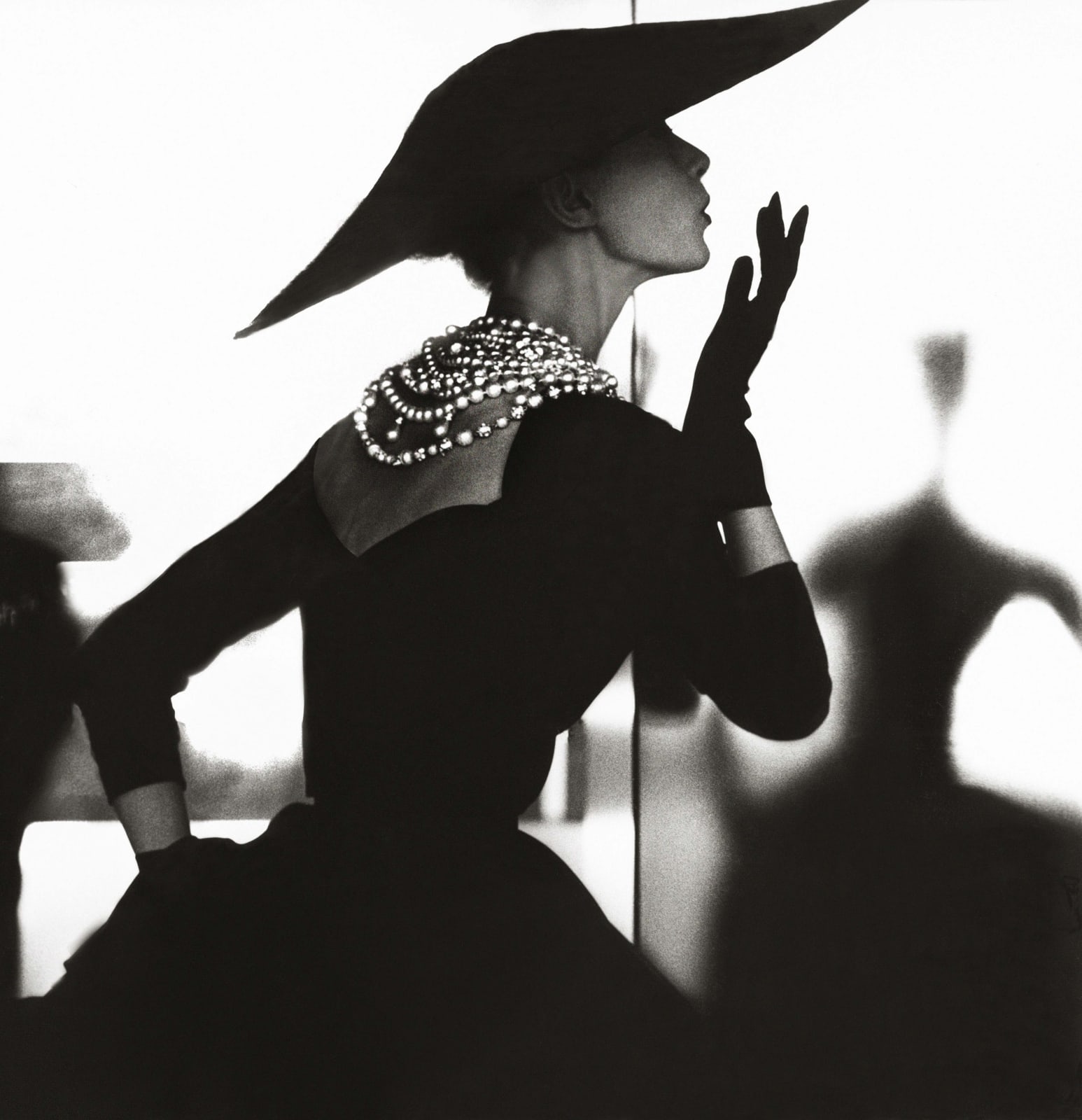 Lillian Bassman photograph of Barbara Mullen in black dress and necklace blowing a kiss