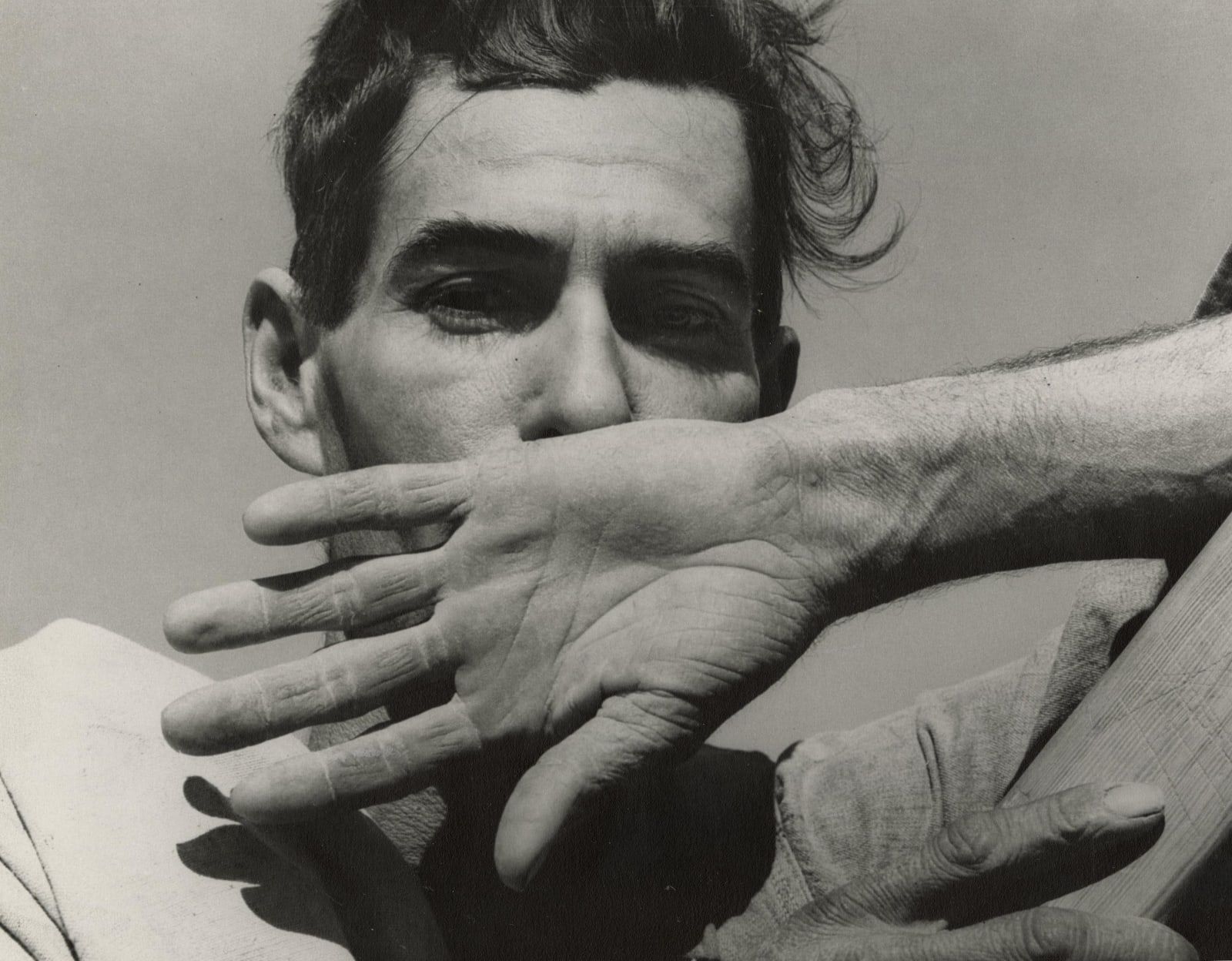 Migratory cotton picker with hand in front of his mouth by Dorothea Lange