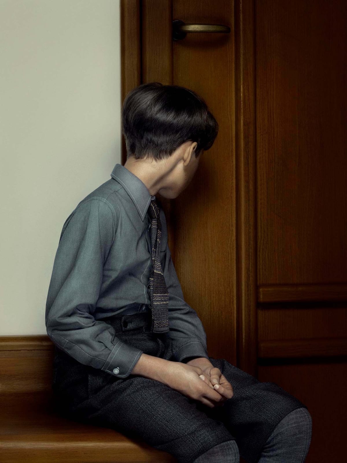 Boy looking through keyhole by Erwin Olaf