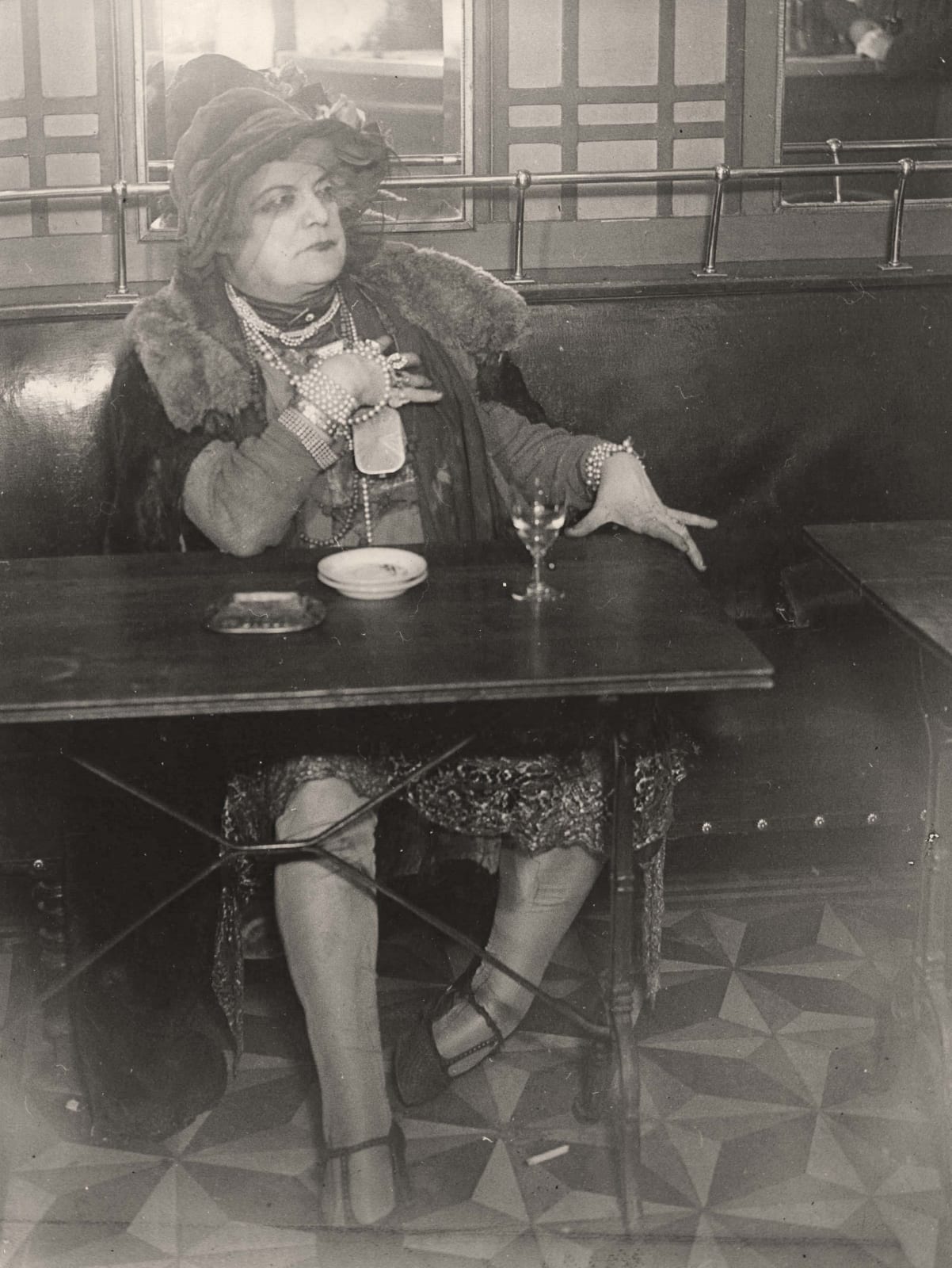 Brassaï La Môme Bijou, Bar de la Lune, Paris at bar table with drink 