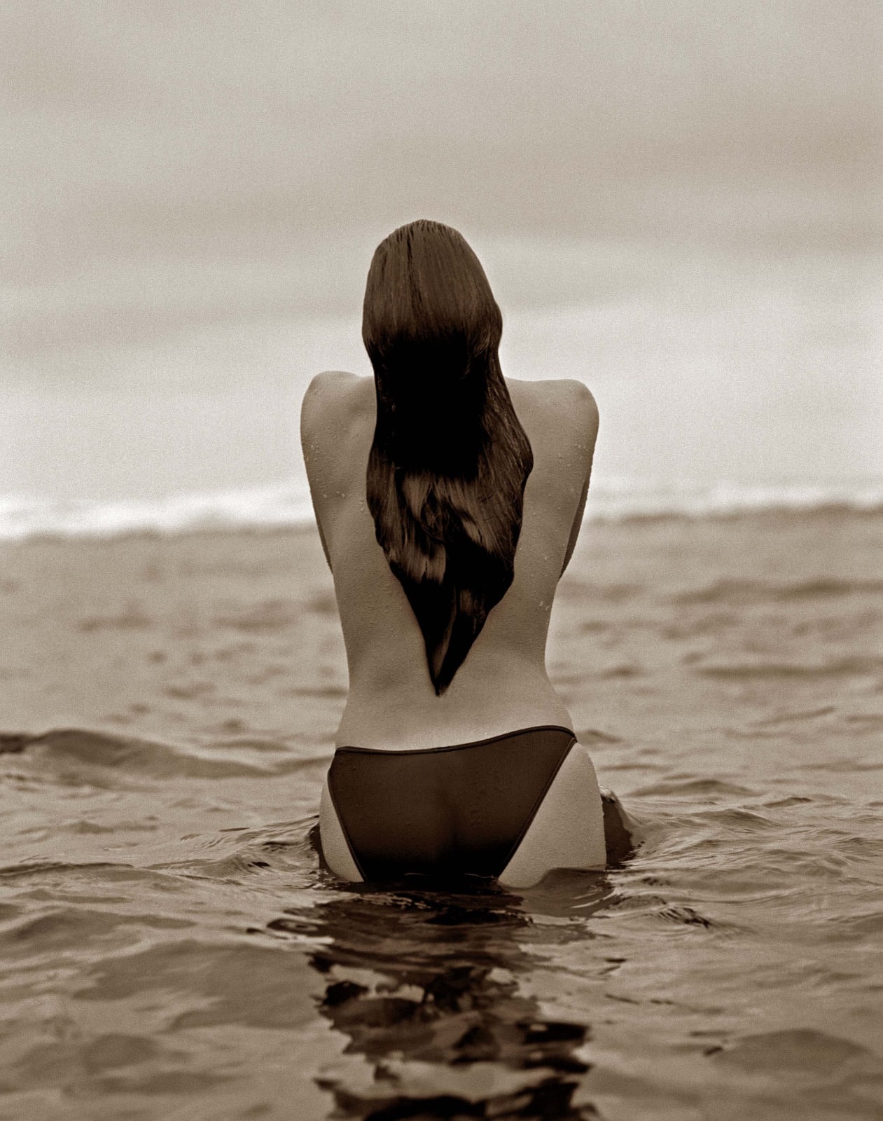 Herb Ritts photograph of woman wearing bikini bottoms in ocean