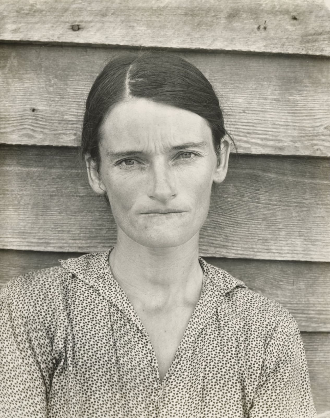 Wife of cotton sharecropper Allie Mae Burroughs standing against wooden slats of her home in Hale County, Alabama by Walker Evans