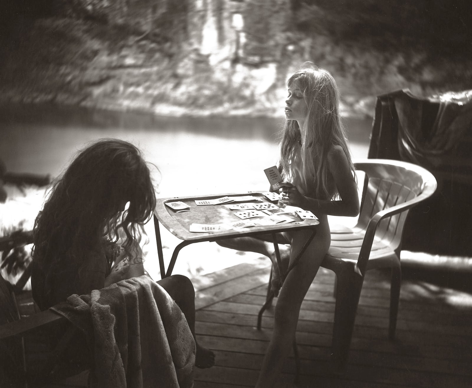 sisters Virginia and Jessie playing war card game outside, from the Immediate Family series by Sally Mann