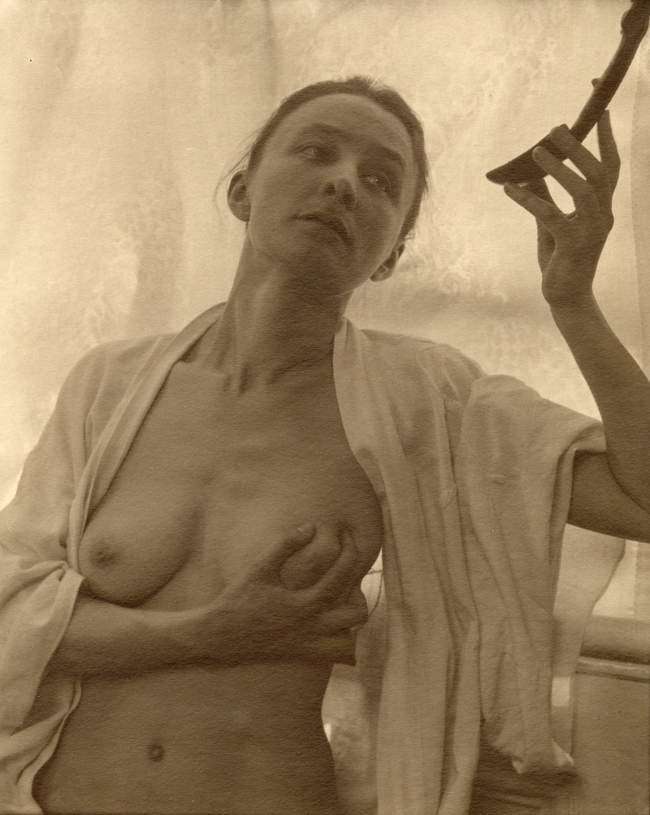 n spoon with right hand and clutching right breast with left hand by Alfred Stieglitz