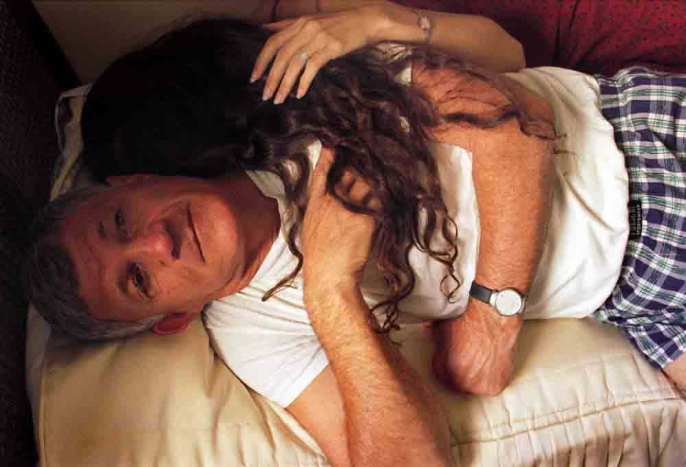 Elinor Carucci My Father and I #1 man lying down holding woman's hair draped over his chest