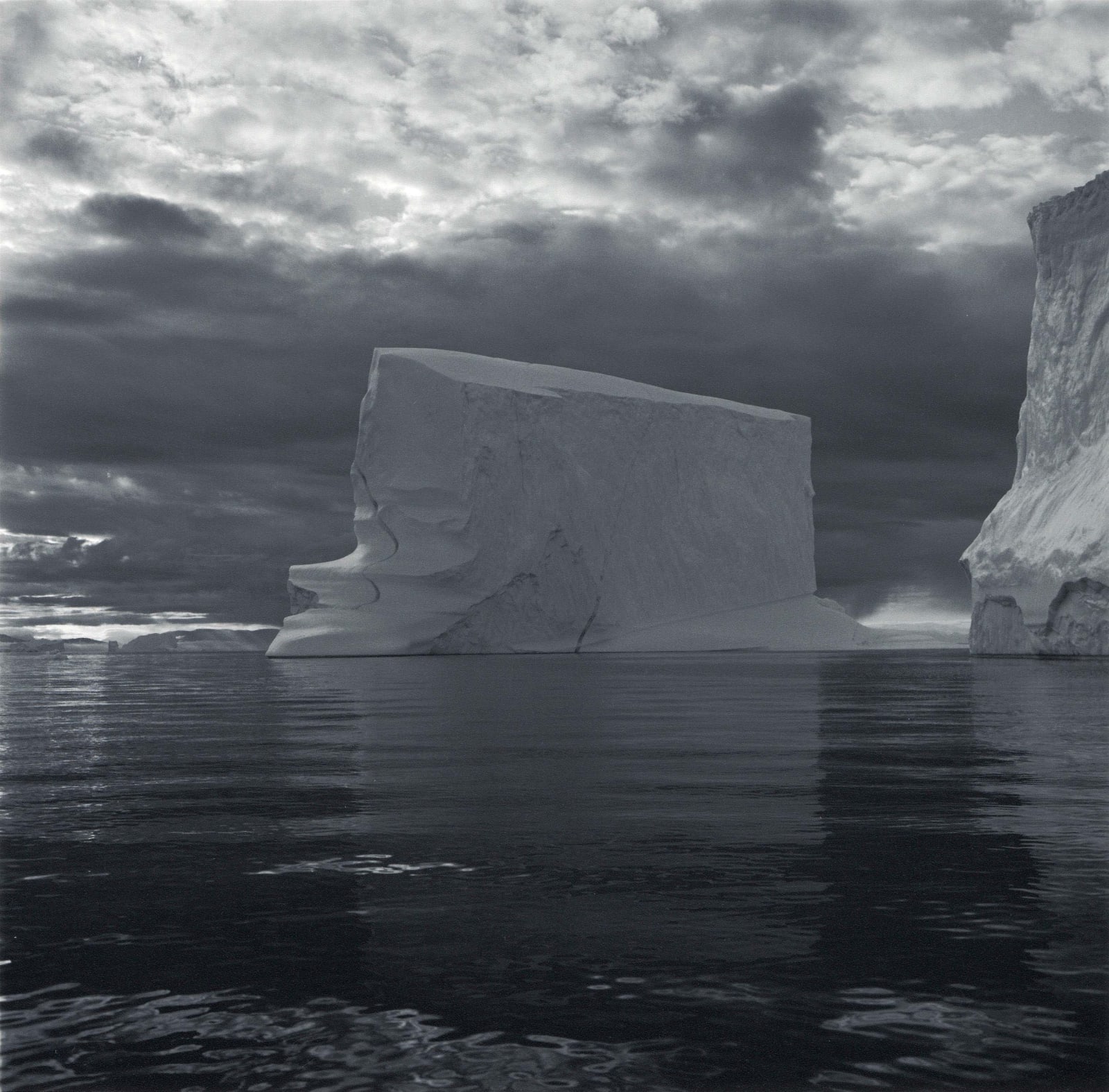 Lynn Davis photograph of geometric iceberg in Disko Bay, Greenland against dramatic sky and inky water