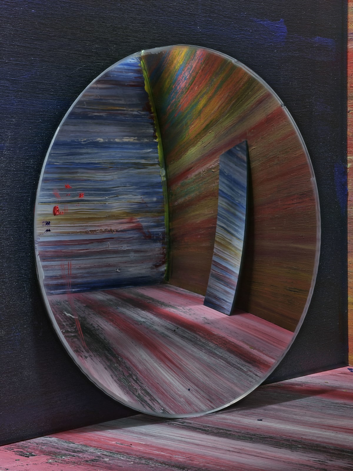 oval mirror reflecting corner of painted room