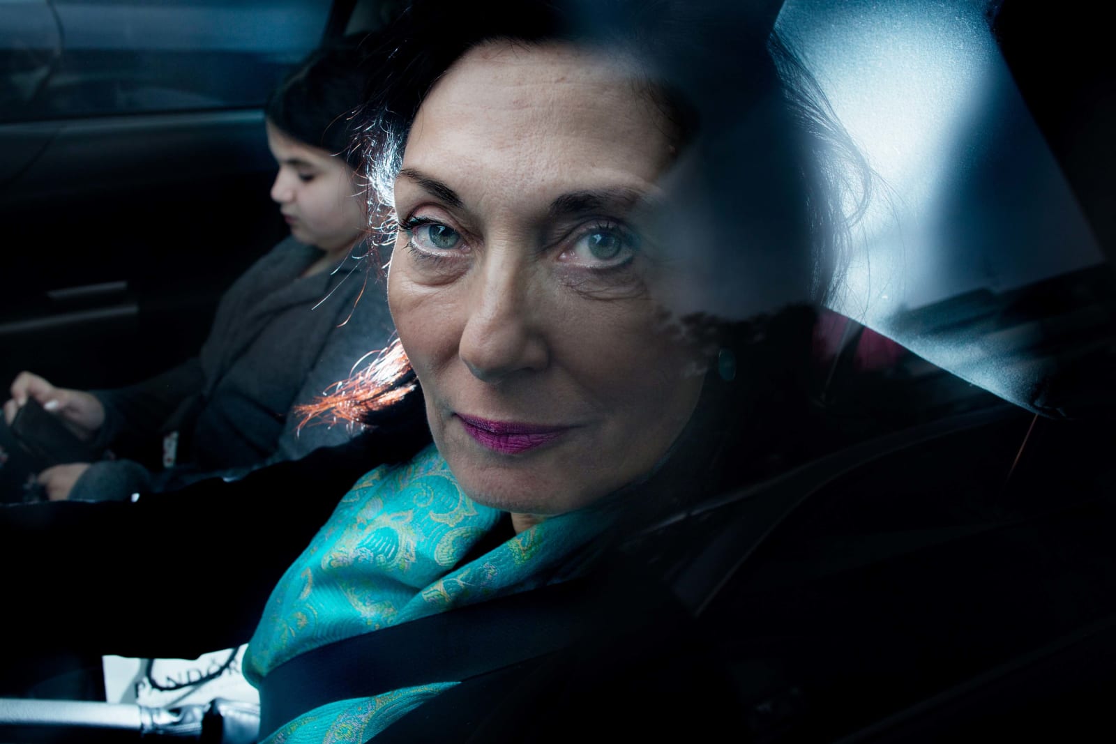 Elinor Carucci photograph of her mother and daughter inside of a car with a close up on her mother's face looking out the window