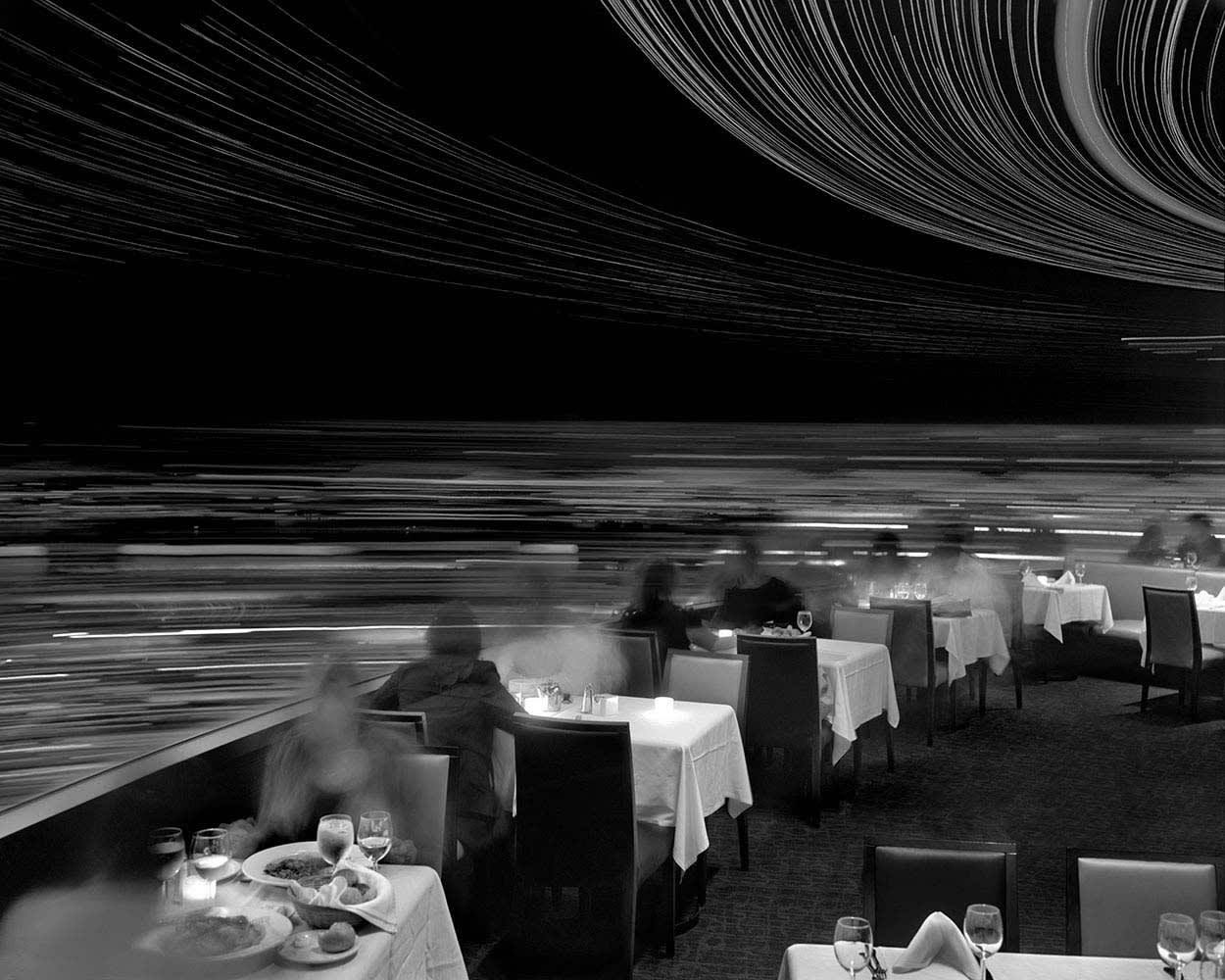 Matthew Pillsbury black and white photograph of diners at revolving restaurant portrayed through long exposure shot