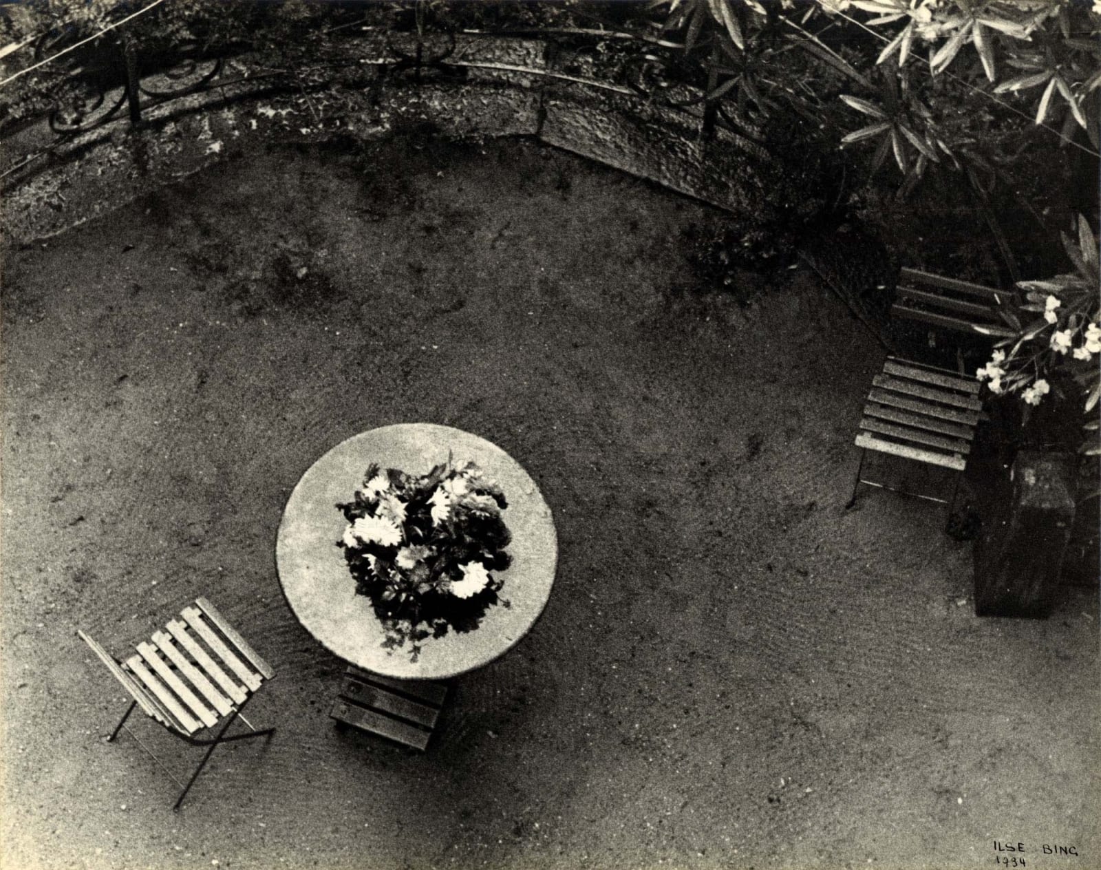 Ilse Bing photograph looking down on table with flowers and two chairs