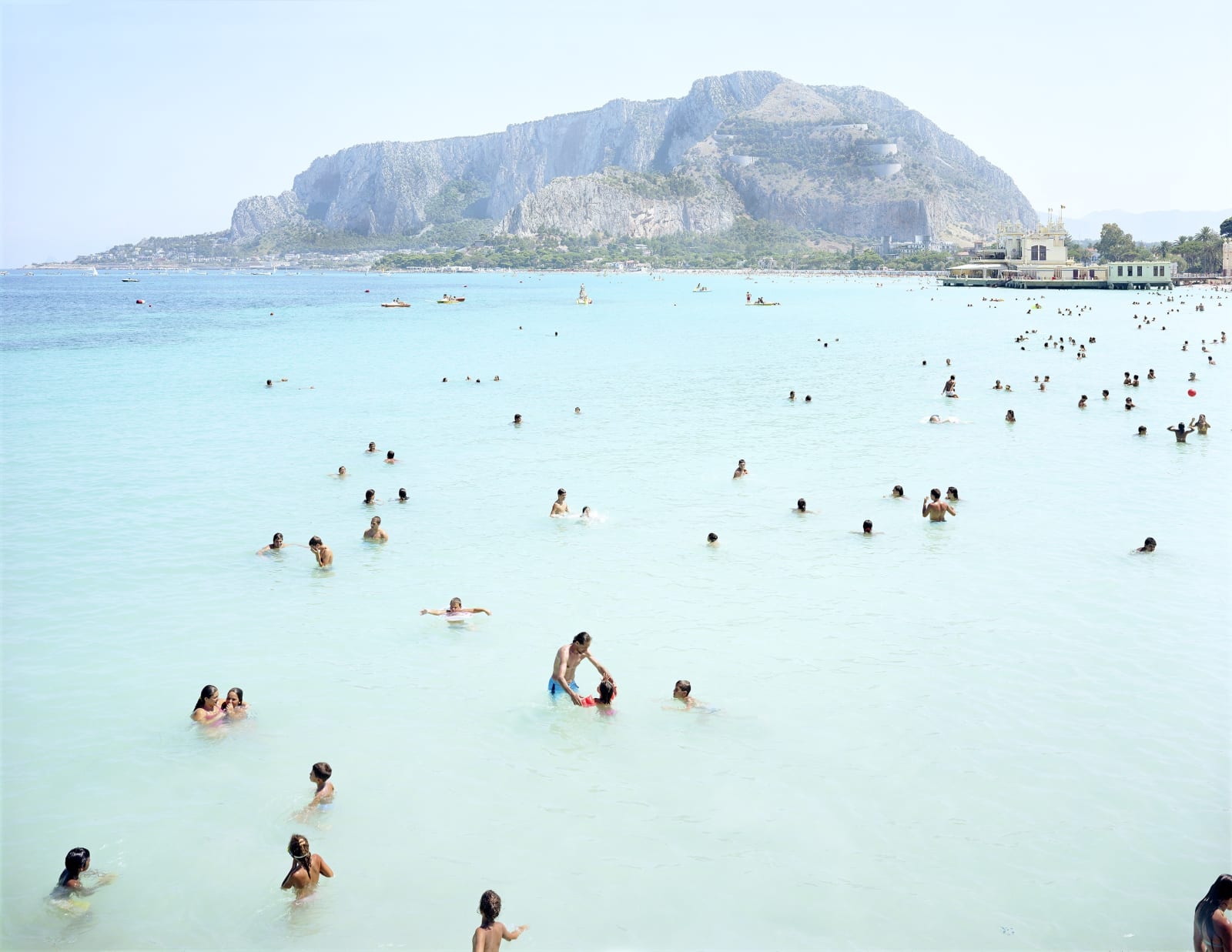 Swimmers in blue ocean at Mondello Monte Pelligrino, Italy by Massimo Vitali