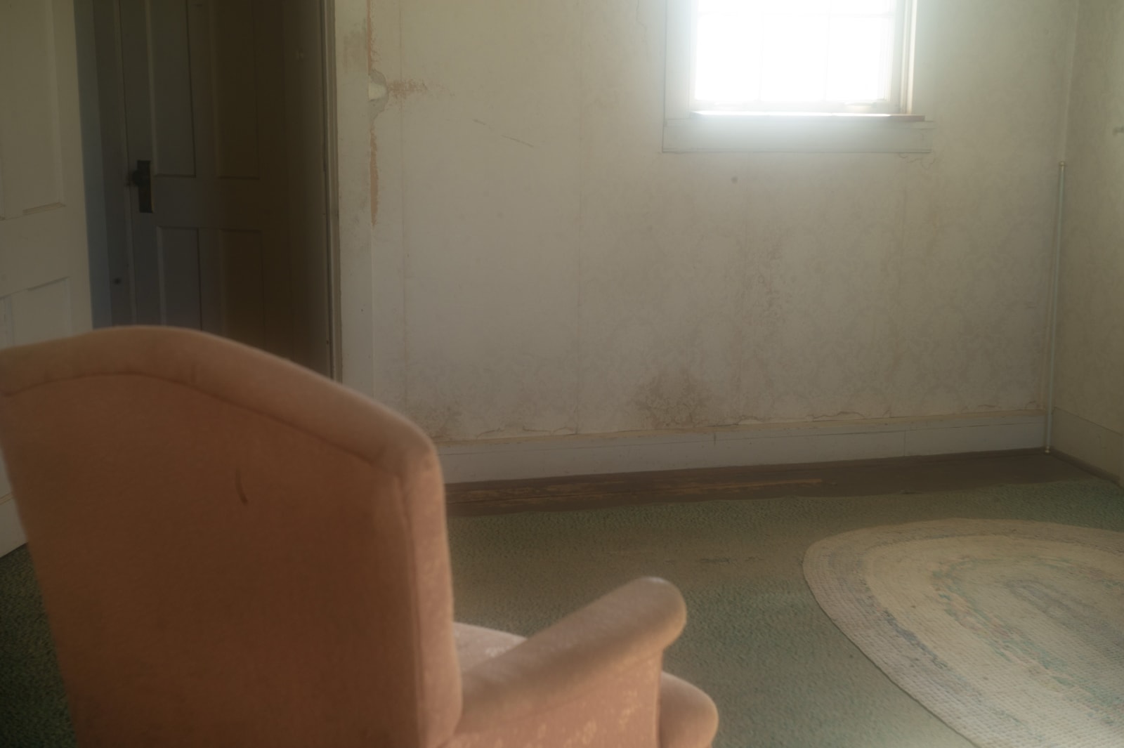 Sally Mann color photograph of a pink chair facing wall with light pouring from exterior window from Delta series