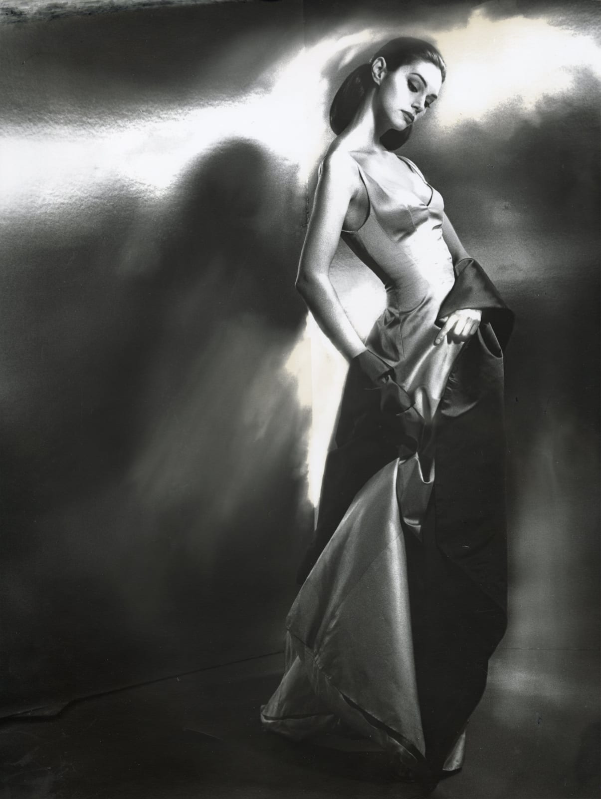 Woman in elegant silk gown posing for fashion advertisement by Lillian Bassman