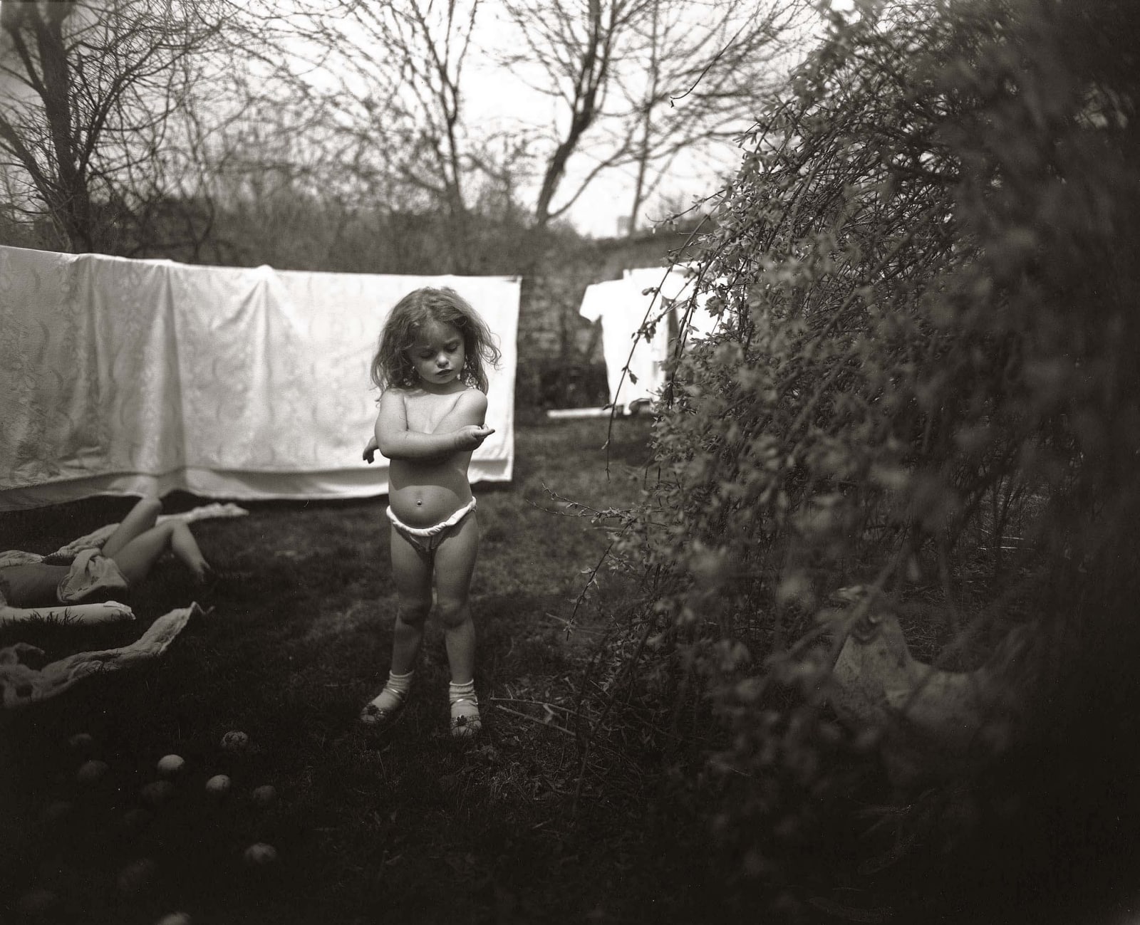 Virginia standing in front of laundry line examining hangnail, from the Immediate Family series, by Sally Mann