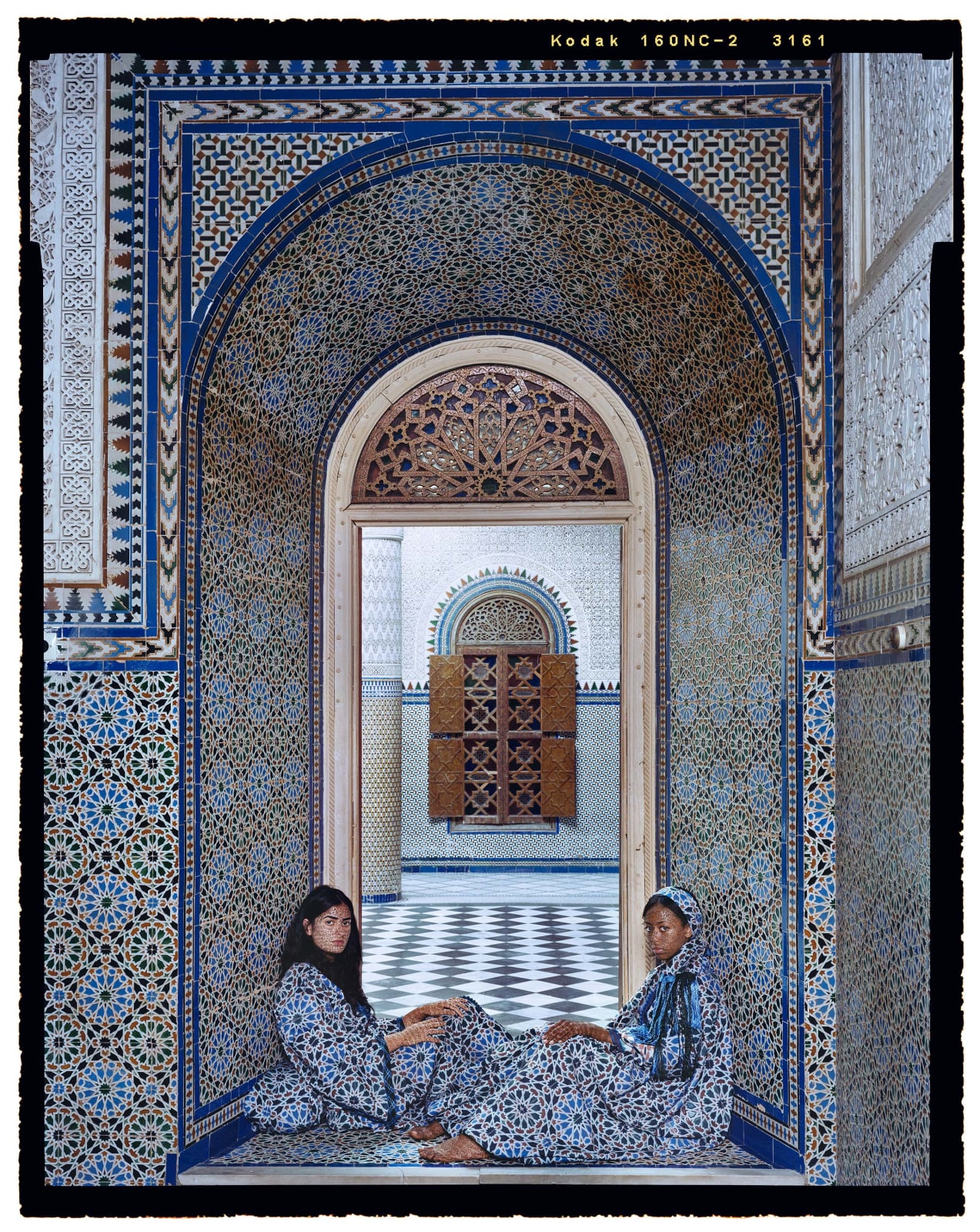 Lalla Essaydi, Harem #14B, Two women sitting in arched tiled doorway in Moroccan palace
