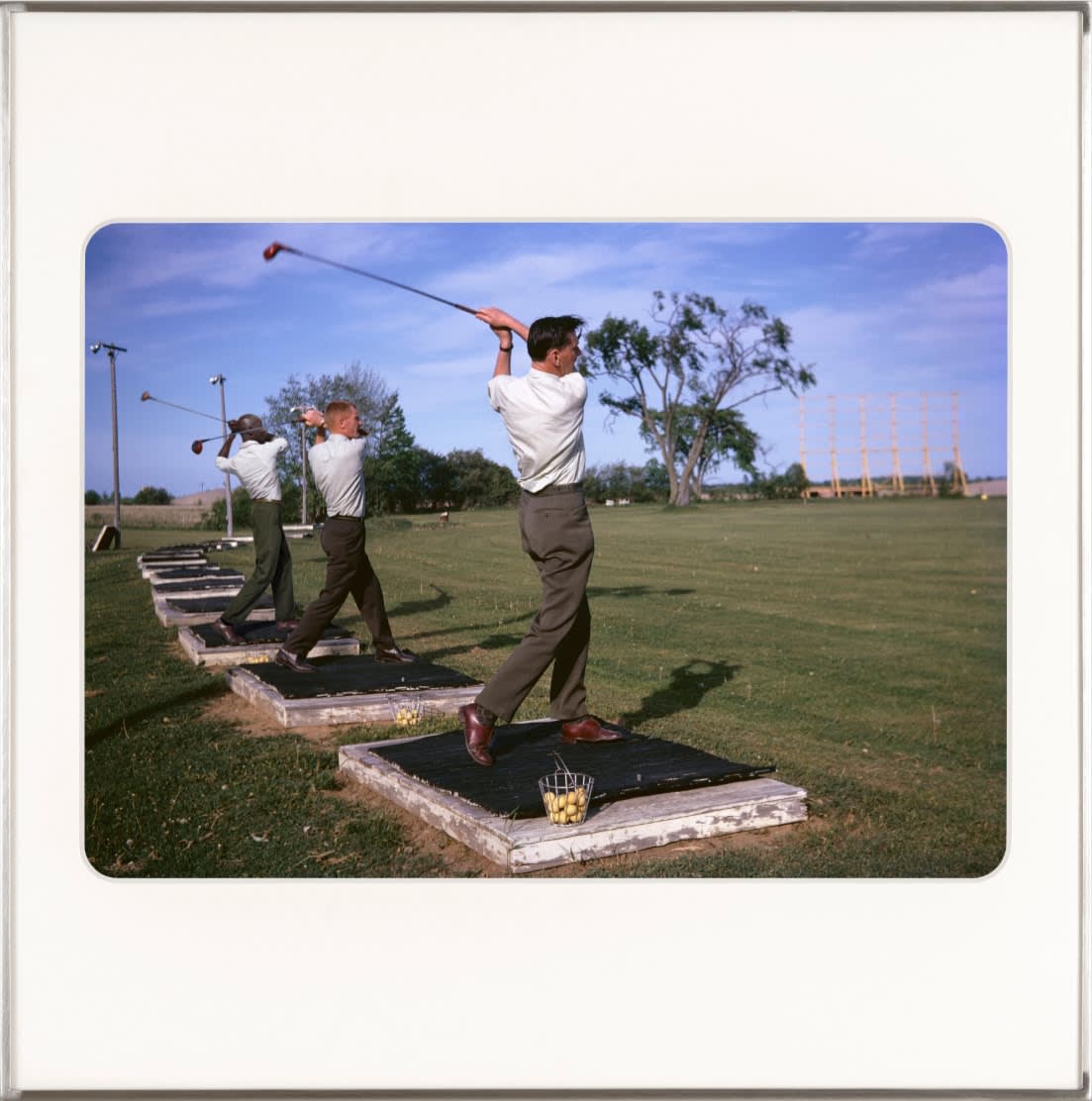 Two white men and artist Omar Diop at the driving range. By Lee Shulman & The Anonymous Project.