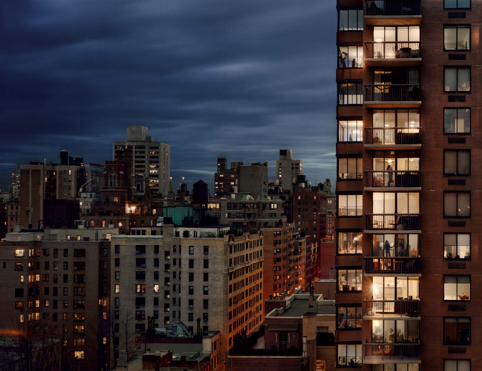 Gail Albert Halaban Out My Window New York Out My Window, Upper East Side, 1438 3rd Avenue, Families Just Before Dinner, 2008 highrise building at night with lit windows dark sky city skyline