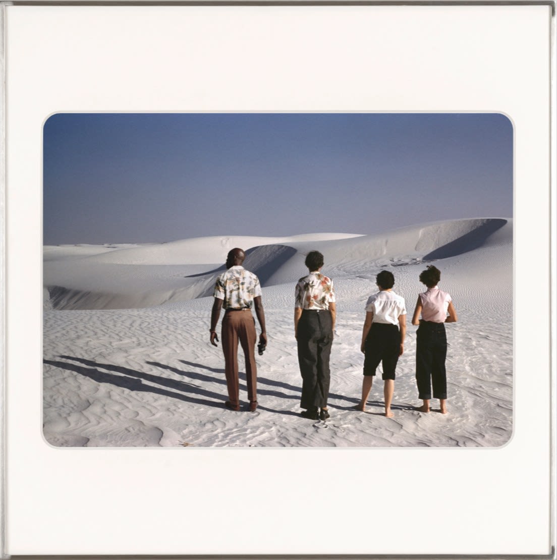 Omar Diop and three woman standing on sand dunes looking out. By Lee Shulman & The Anonymous Project.
