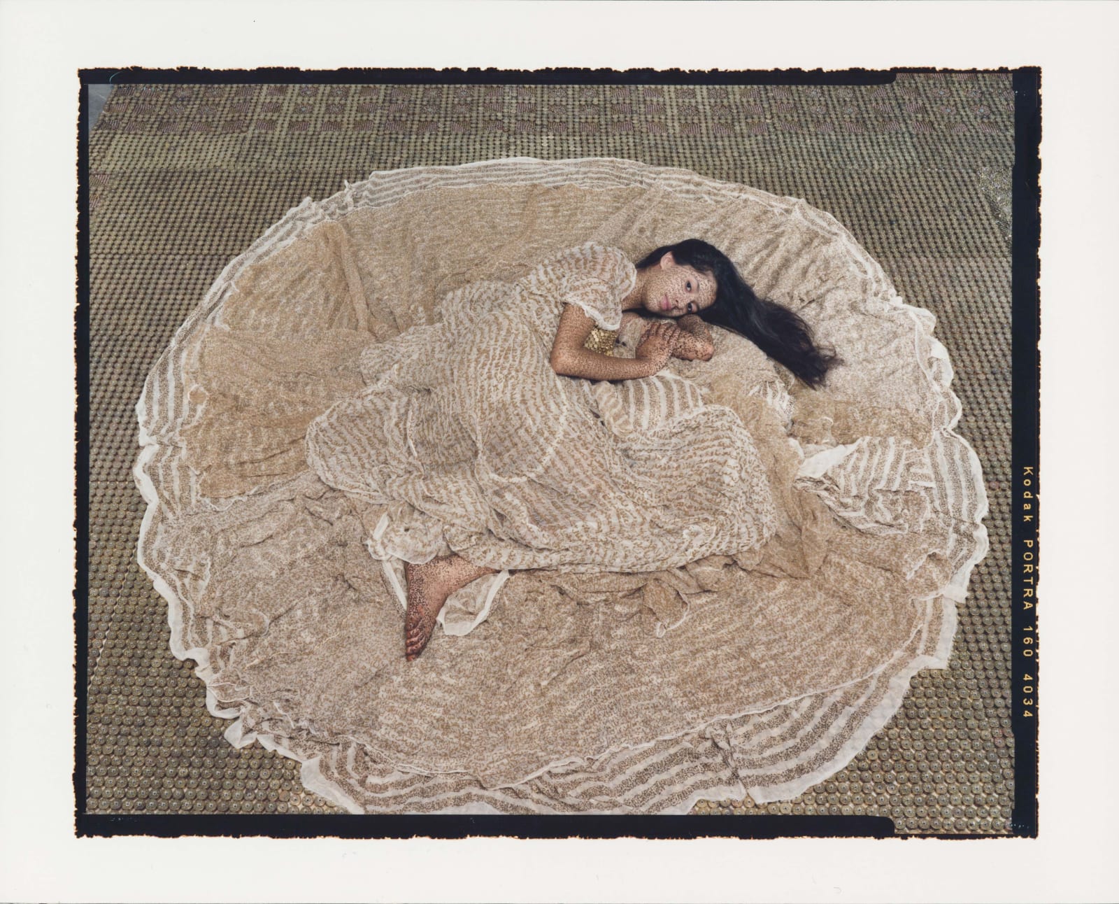 Woman lying on floor with her dress in a circle around her, by Lalla Essaydi