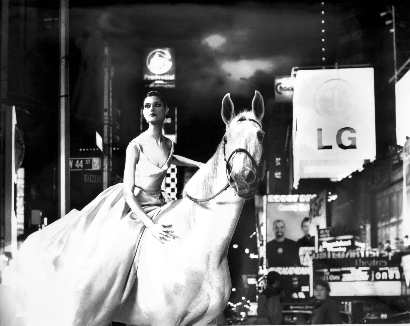 young woman in gown on white horse in Times Square at night, by Lillian Bassman