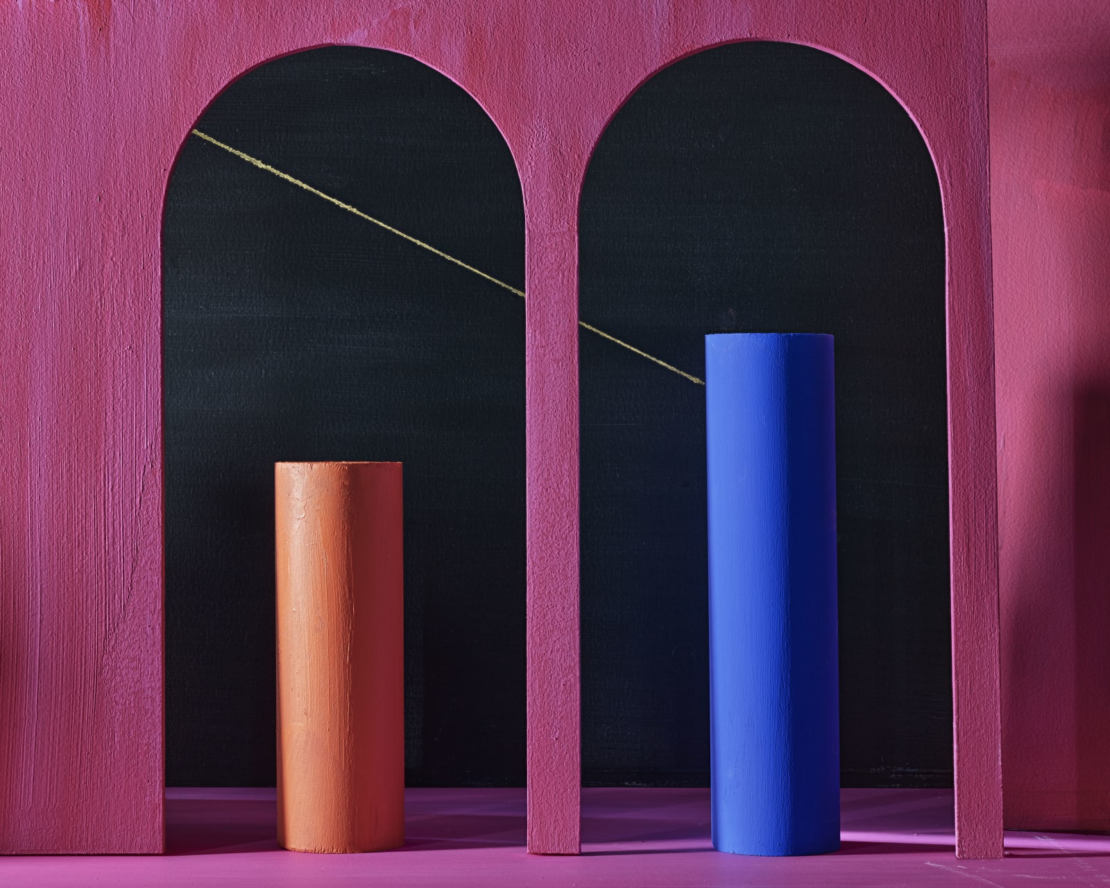 red and blue cylinders in front of black alcoves