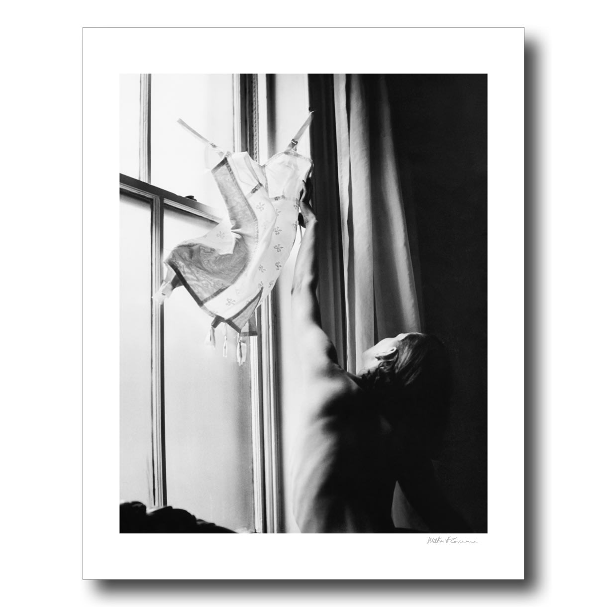 Milton H. Greene, An unknown woman hangs up a girdle for a fashion photoshoot for Vogue Magazine