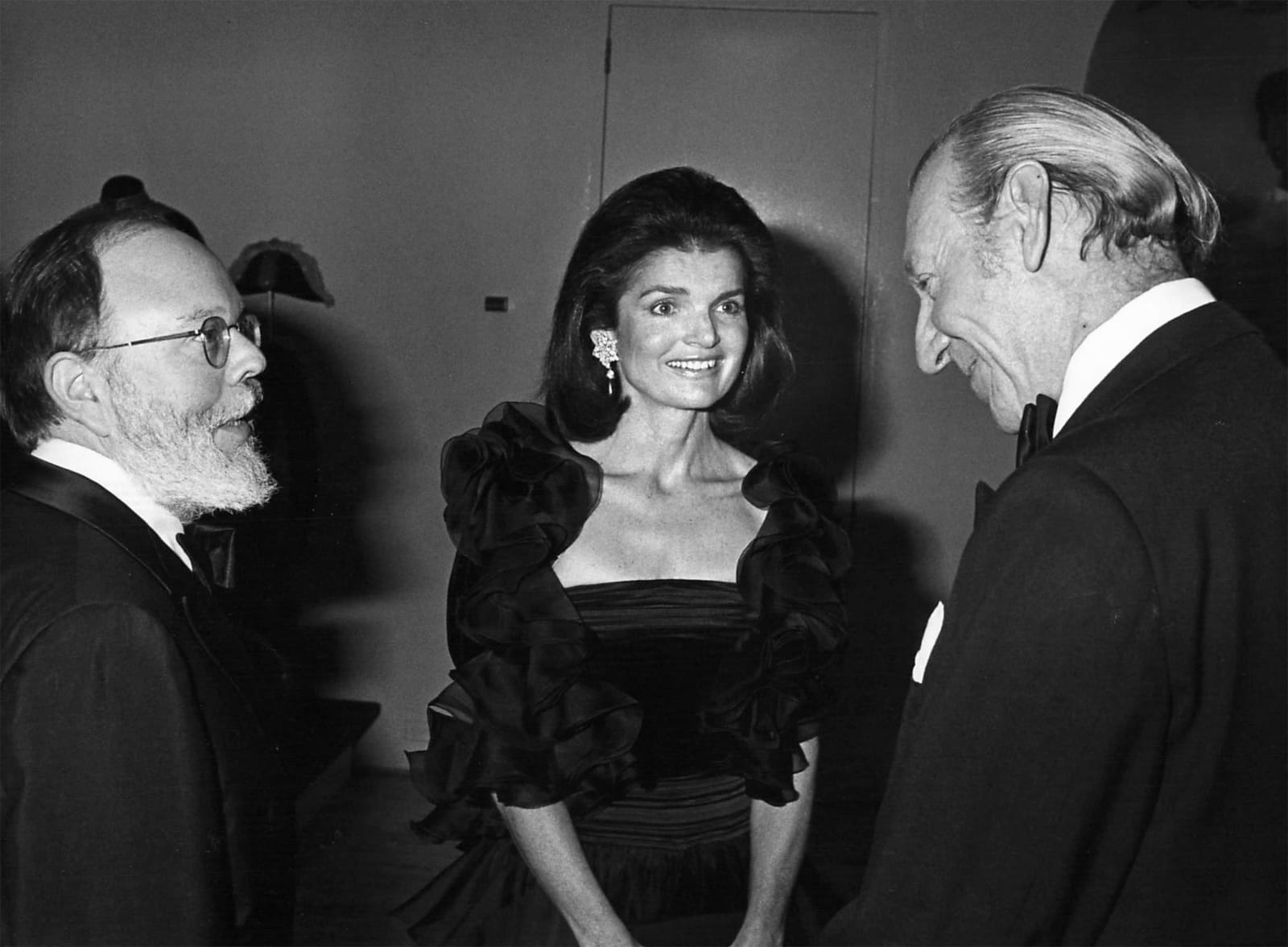 Ron Galella, Bill Sargent (Viking Press), Jackie Kennedy Onassis and escort Sir Hugh Fraser at gala opening of new costume exhibit of "Fashion of the Habsburg Era", Metropolitan Museum of Art, December 3 , 1979
