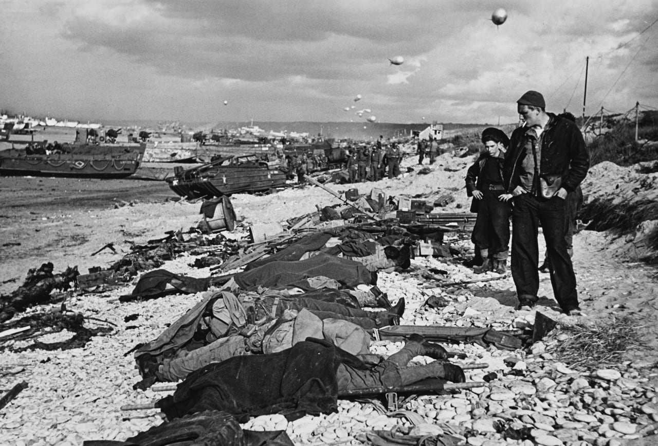 Robert Capa, French fishermen looking at fallen soldiers before funeral on Omaha Beach, June, Normandy, France, 1944