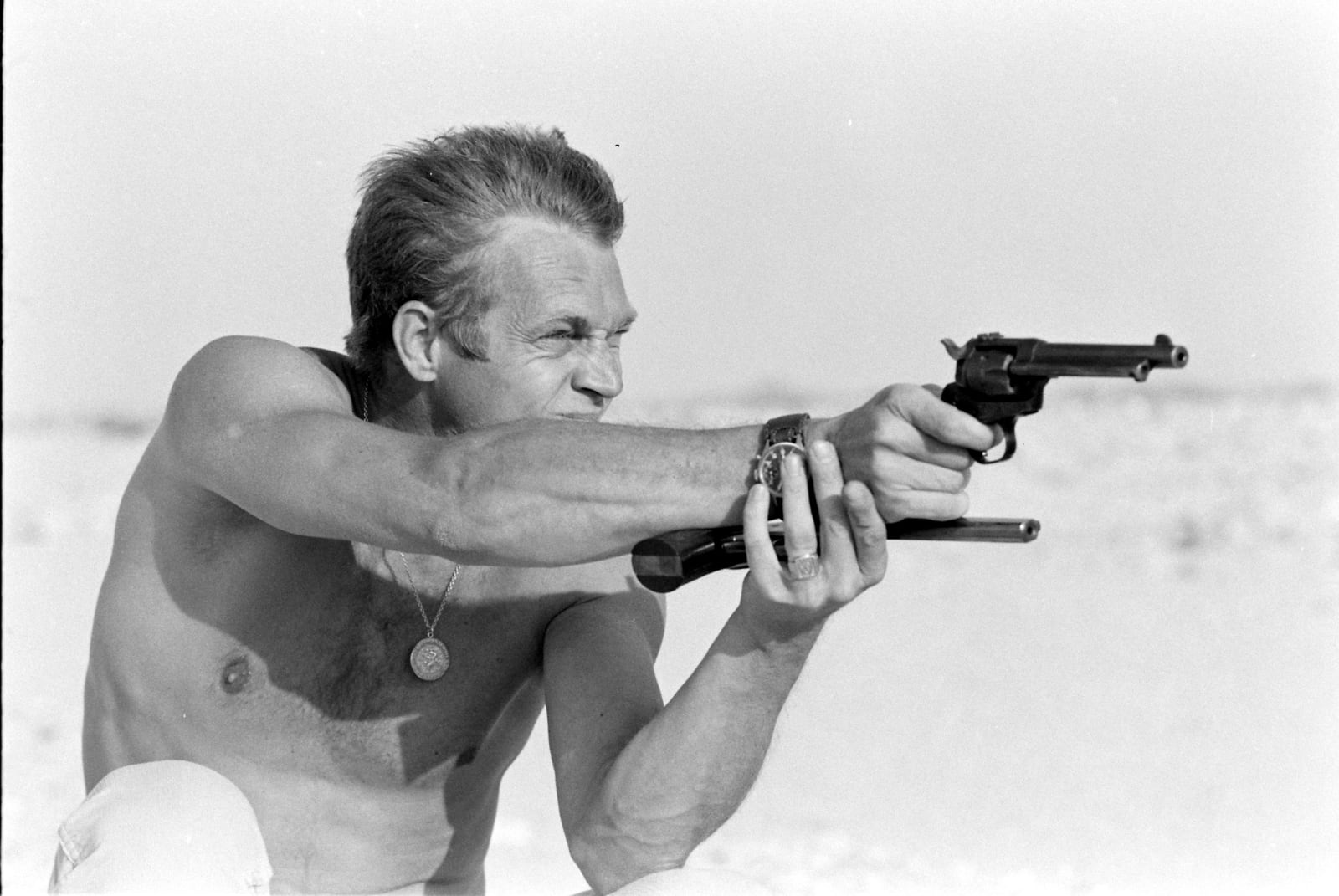 John Dominis, Steve McQueen aiming a pistol in the desert, CA, 1963