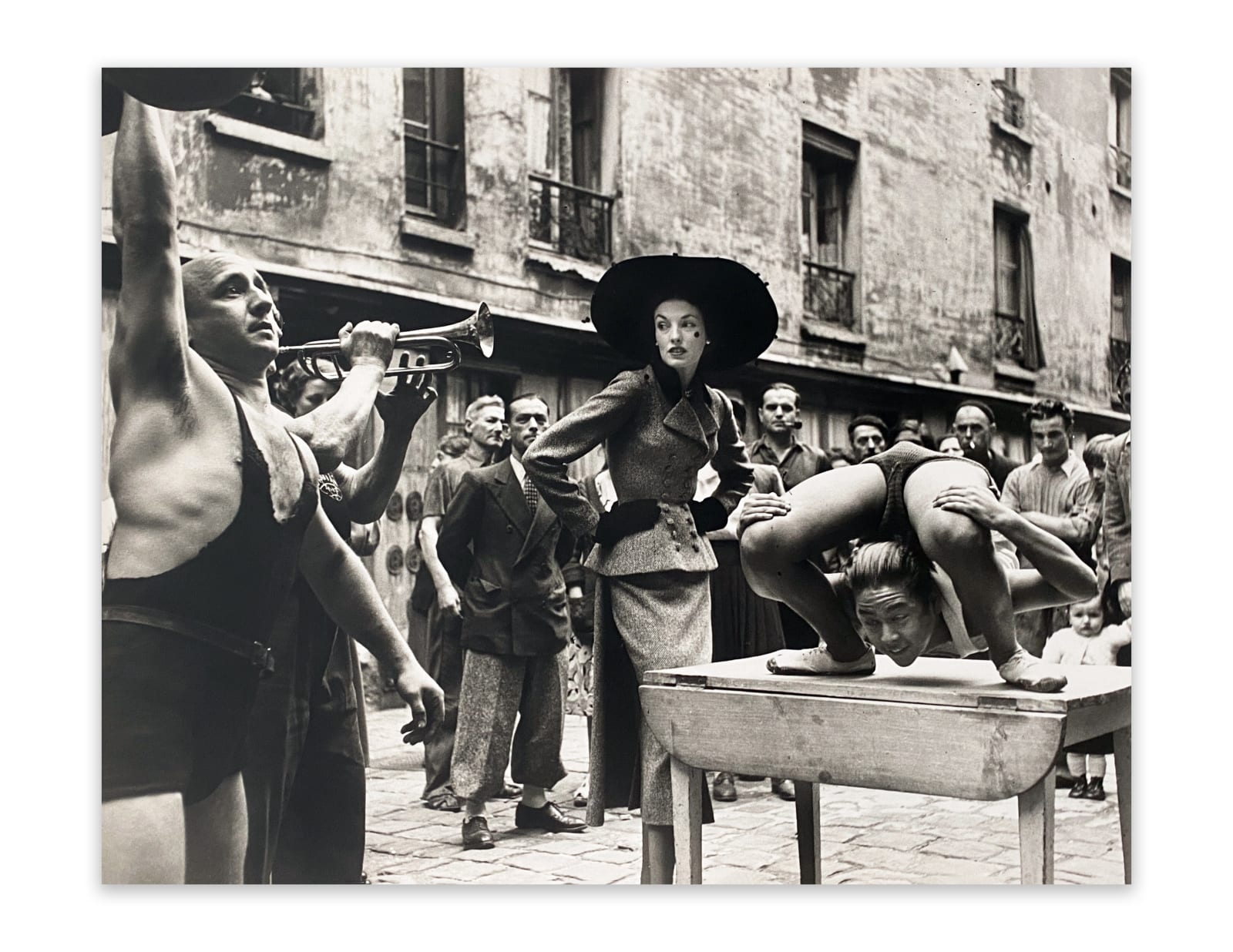 Richard Avedon, Elise Daniels with Street Performers, Suit by Balenciaga, Le Marais, Paris, 1948