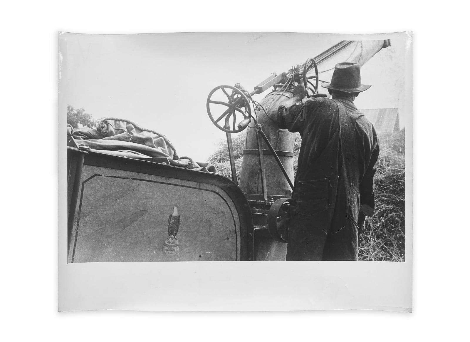 Ben Shahn, Adjusting straw stocker on grain separator, central Ohio, 1938