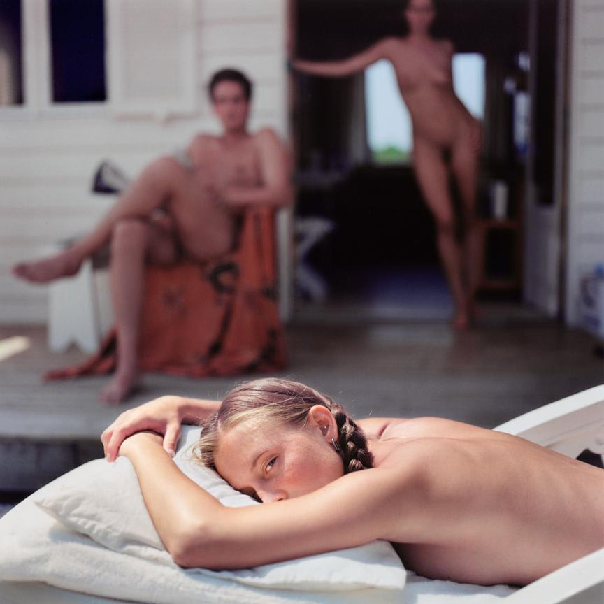 Mona Kuhn, Natalie (girl laying on sunchair, looking with one eye), 2003