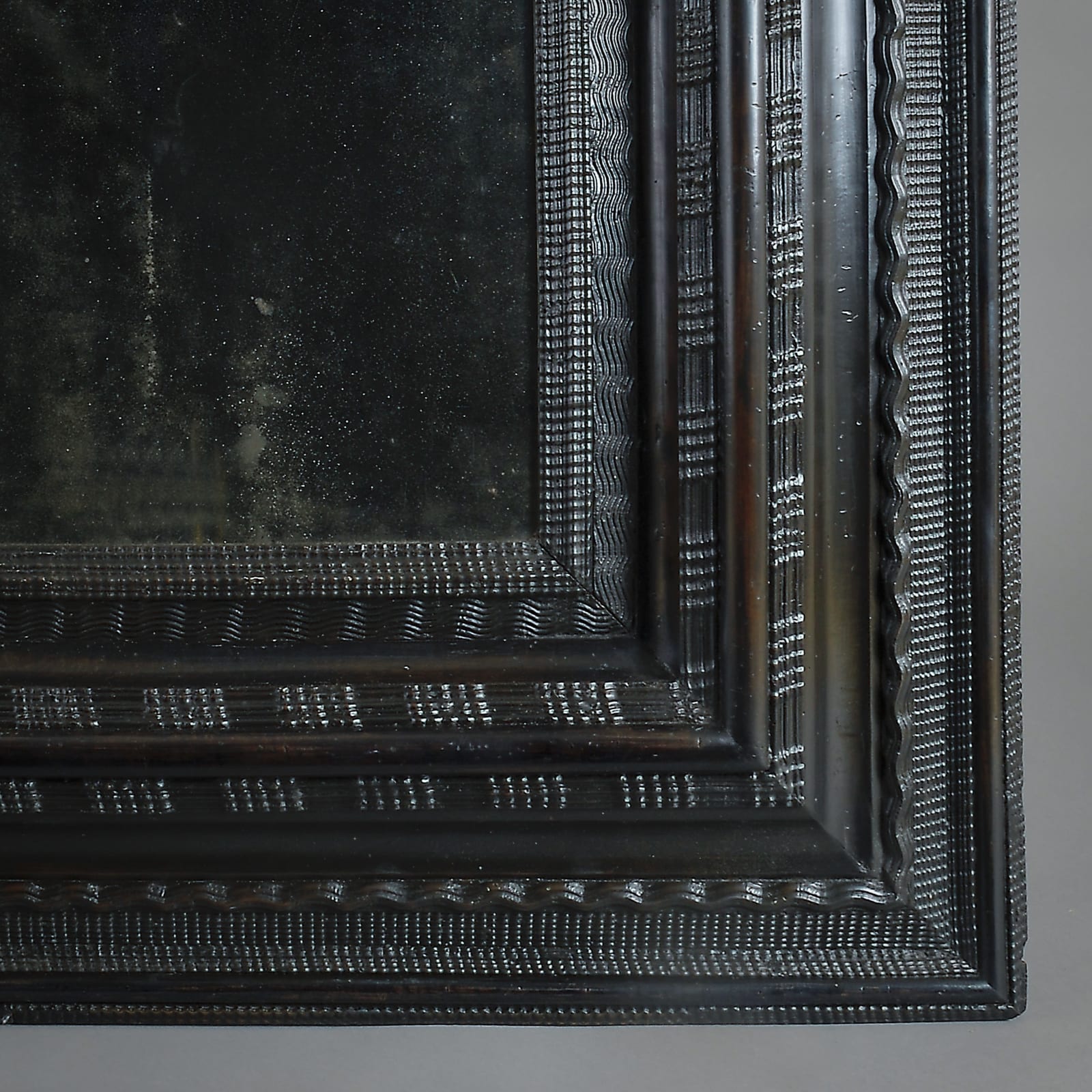 NORTH ITALIAN EBONISED RIPPLE-MOULDED MIRROR