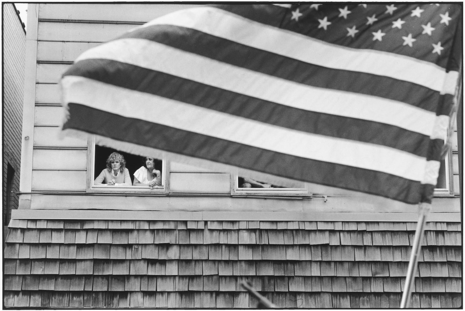 Tom Arndt Two women & the flag, Payne Avenue, Saint Paul, Minnesota Tirage gélatino-argentique postérieur, réalisé par l'artiste 20,8 x 31 cm Dim. papier: 27,9 x 35,3 cm