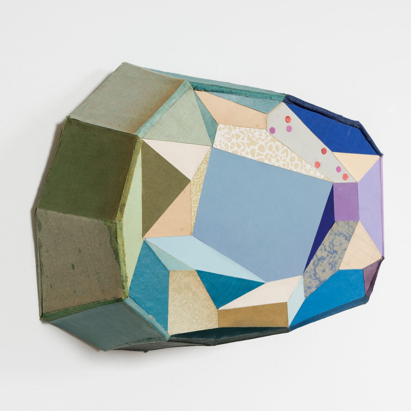 Left view of geometric relief sculpture with green and purple