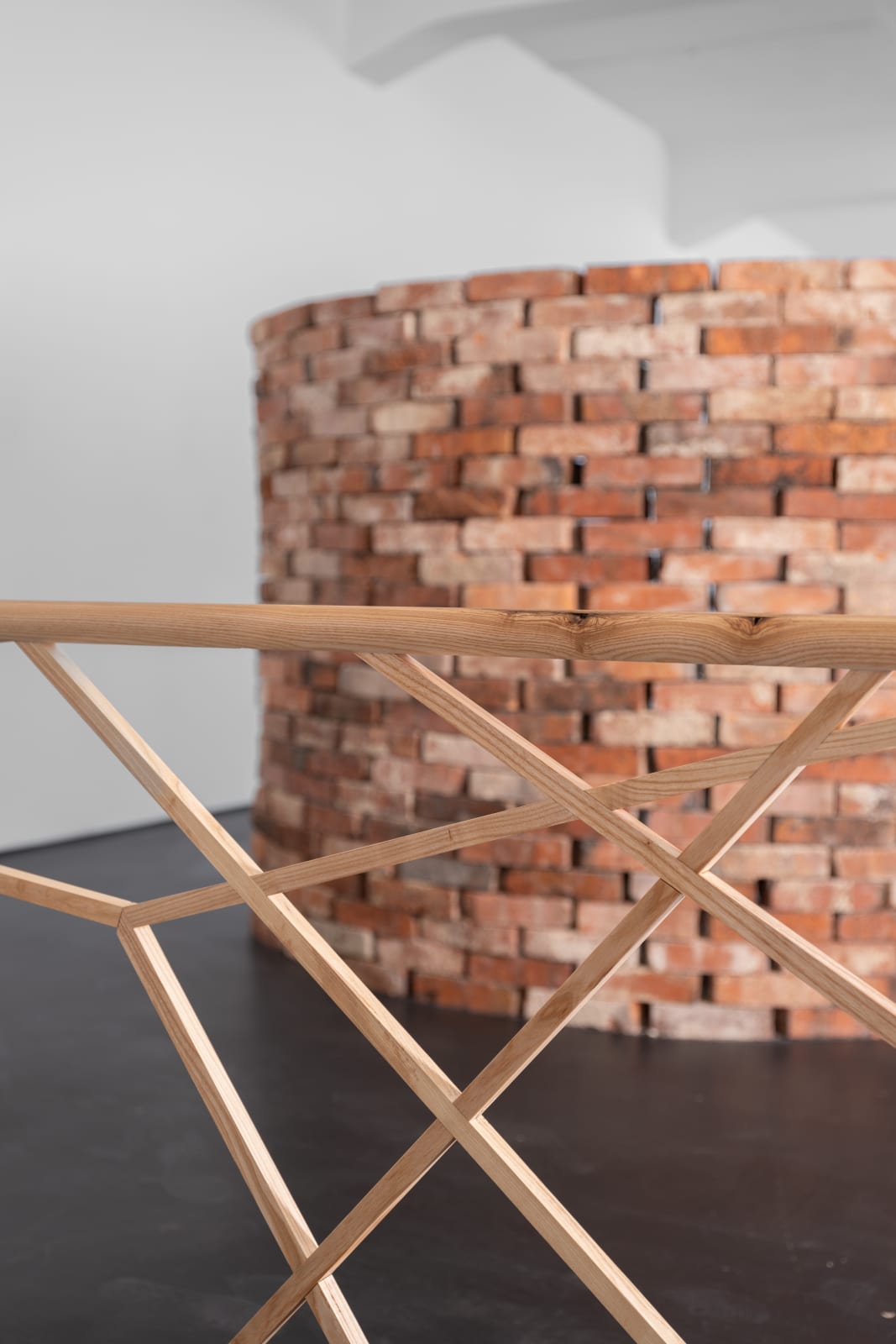 Partial view of wooden railing structure with vertical and horizontal wooden balance beams running through it and a brick wall behind it Rindon Johnson Fruit of the poisonous tree, Higher and more free! The music must always play, All the conventions conspire to make this fort assume the furniture of home; Lest we should see where we are, higher and more free! Lost in a haunted wood, What are the consequences of two different forms interacting? Ice on a bed of mint leaves. That’s what I thought in the early morning. Higher and more free! Breeze engine. If no is what it is then that’s what it is. Breeze Engine. Paint dries on walls. Bells chime at noon. Rivers flow through canyons. Enough. Enough. Enough. Enough. Enough., 2023 Ash wood 420 x 67.5 x 16.5 cm 165 3/8 x 26 5/8 x 6 1/2 inches