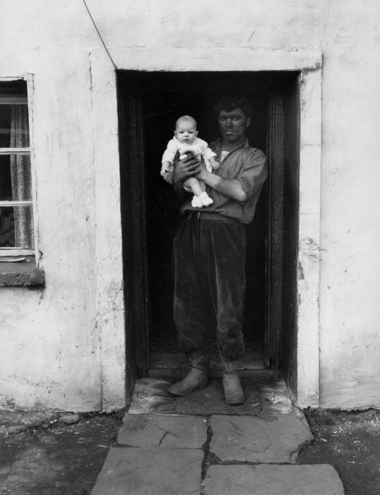 Bruce Davidson, Dark Faced Coal Miner Holding Baby, Welsh Series, 1965