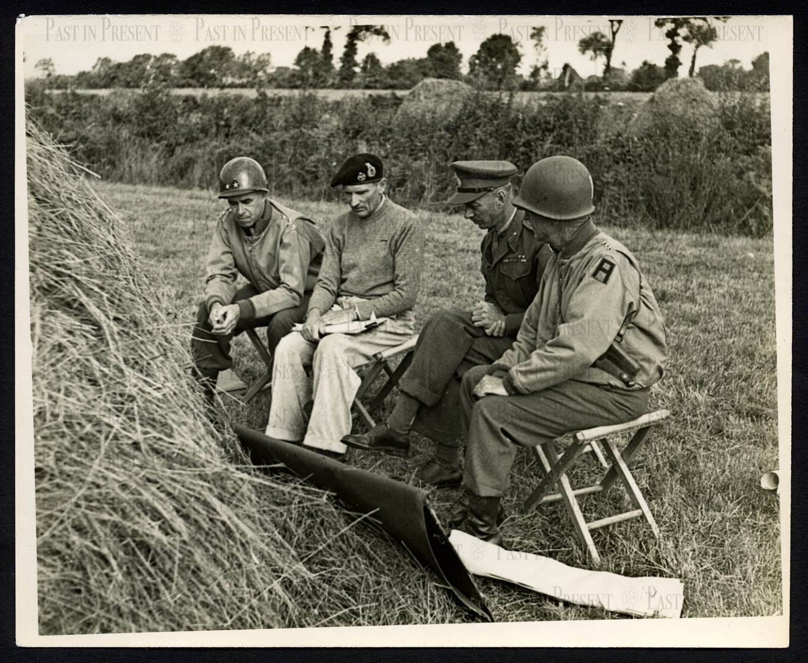 Famous shot of Allied commanders having a war conference by a haystack in a field in Northern France, 8.21.44, 1944