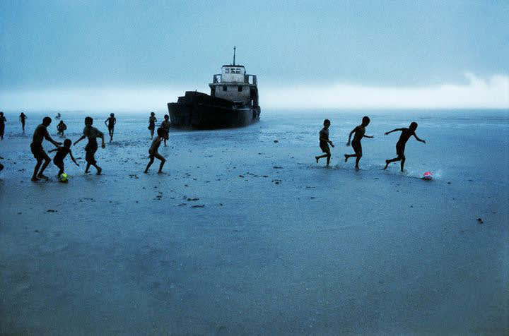 Steve McCurry, Children Playing Football with Abandoned Boat, Burma, 1995