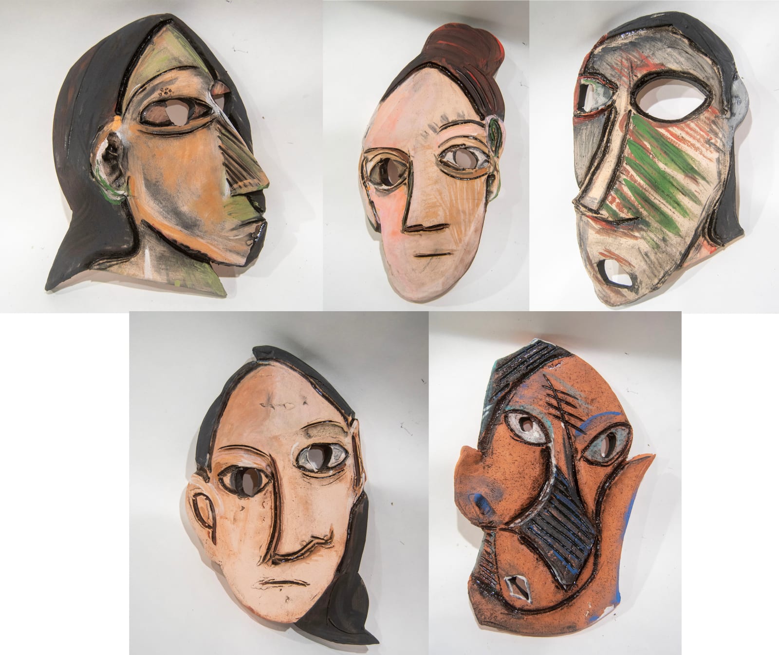 A collection of five masks with elongated faces by artist Reniel Del Rosario.