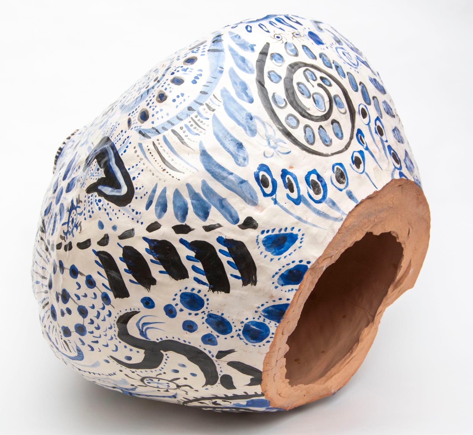 A decorated vase on its side with the bottom broken off by artist Reniel Del Rosario.