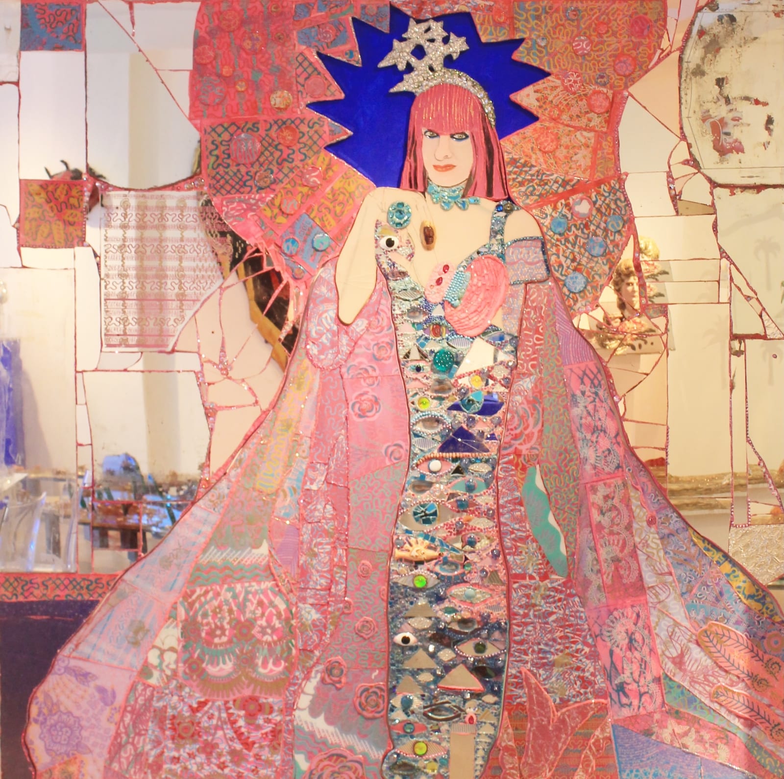 Large mixed media mirrored portrait of British fashion designer Zandra Rhodes. The artwork created by British sculptor Andrew Logan, is intricately decorated with fractures and details in bold pinks, blues and silvers.