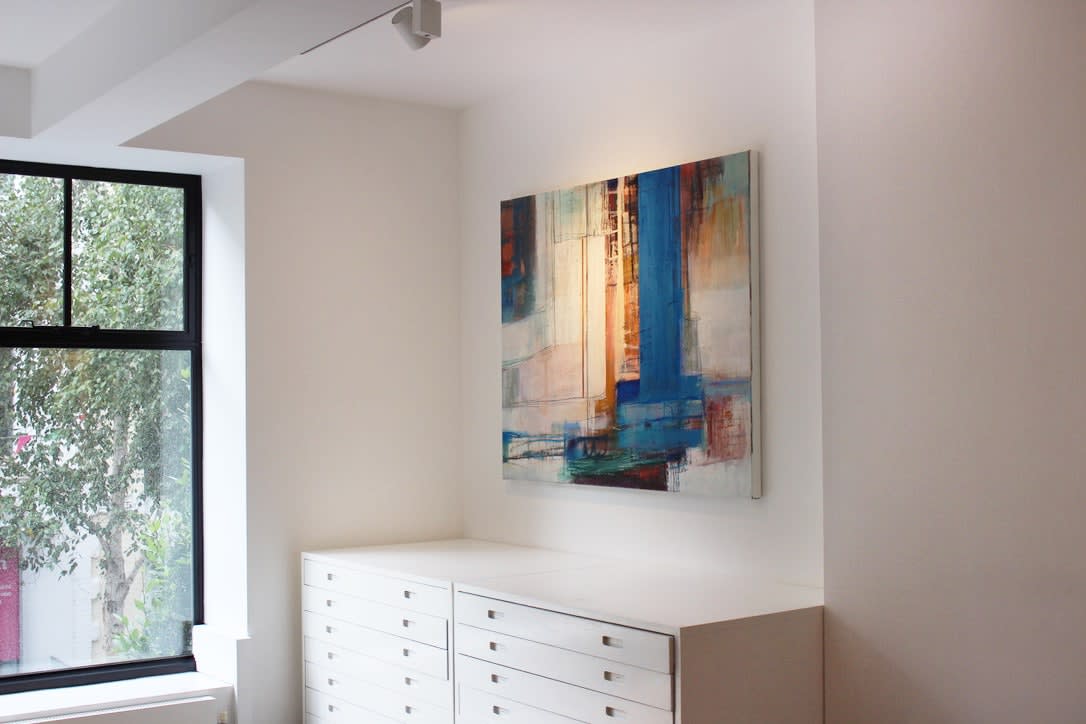 A geometric abstract work with complex textures and blue and yellow colours on display at an art fair.
